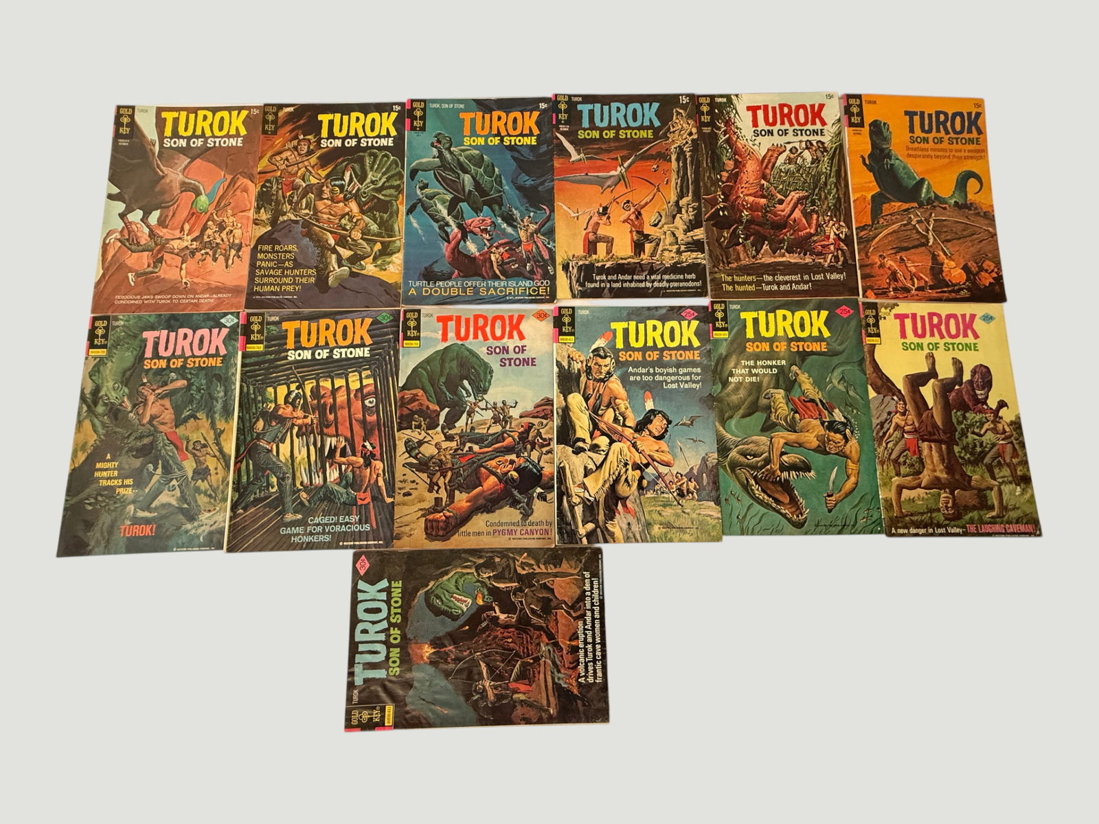 Turok Son of Stone Gold Key Comics Collection — 13 Issues, 1970s: A collection of 13 issues of 'Turok Son of Stone' published by Gold Key Comics, spanning the early-to-mid 1970s era based on cover price indicators (15¢, 20¢, 25¢, and 30¢ editions visible). The s