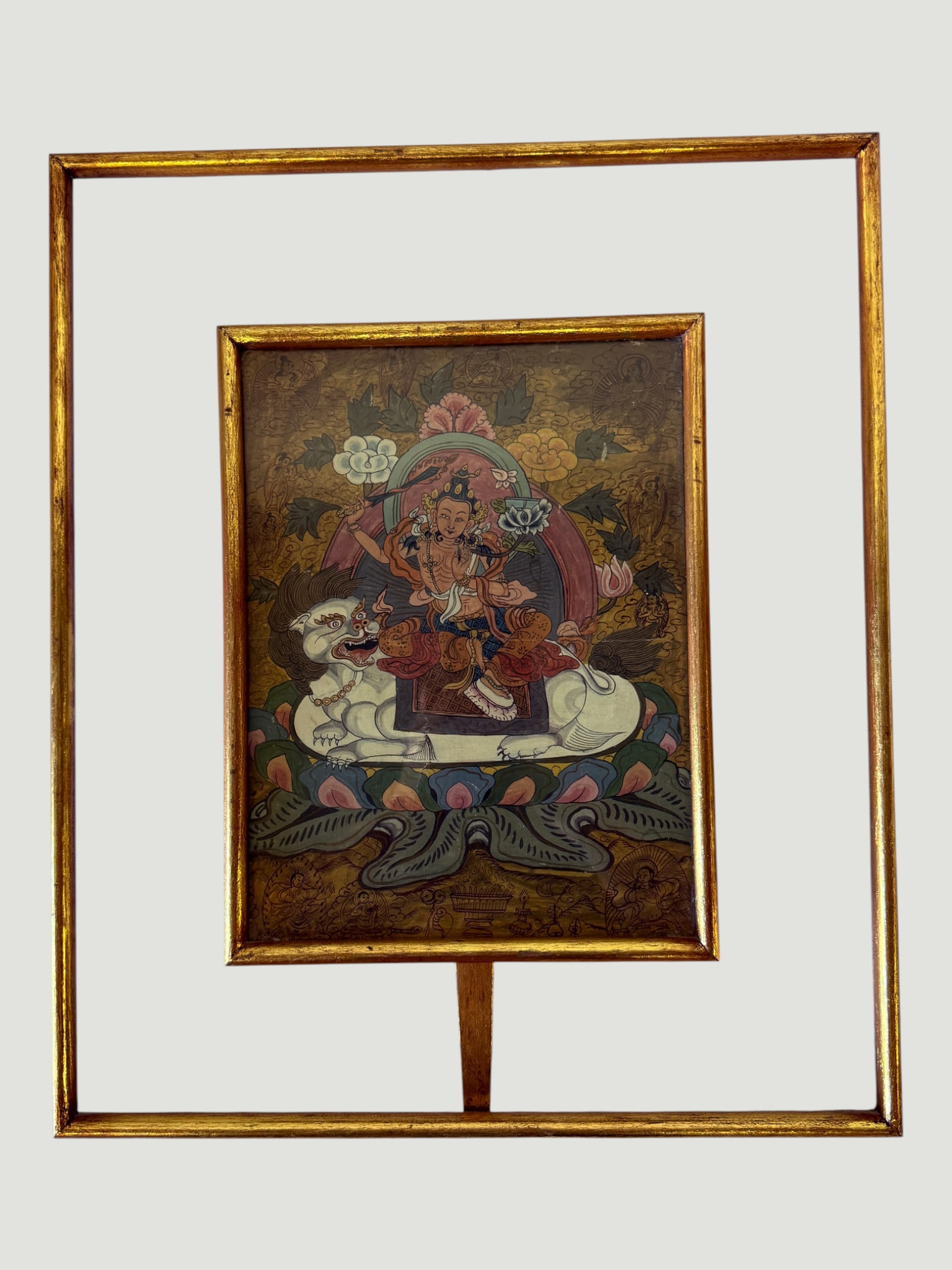 Tibetan Thangka Painting, Deity Figure on Lion Throne, Gilt Frame: A finely detailed Tibetan thangka painting depicting a multi-armed deity (likely Manjushri or a wrathful Bodhisattva) seated upon a white snow lion throne, rendered in traditional mineral pigments on 