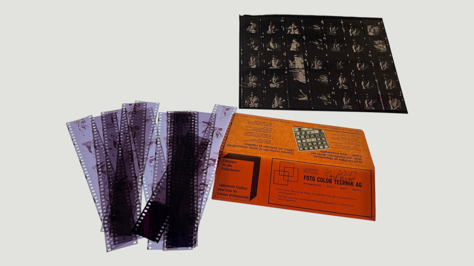 Vintage 35mm Film Negatives & Contact Sheet, Stutz Foto Color Technik AG Zürich: A collection of vintage 35mm color negative film strips alongside a black-and-white contact proof sheet, presented on a light box for examination. The negatives appear to depict candid or documentary-