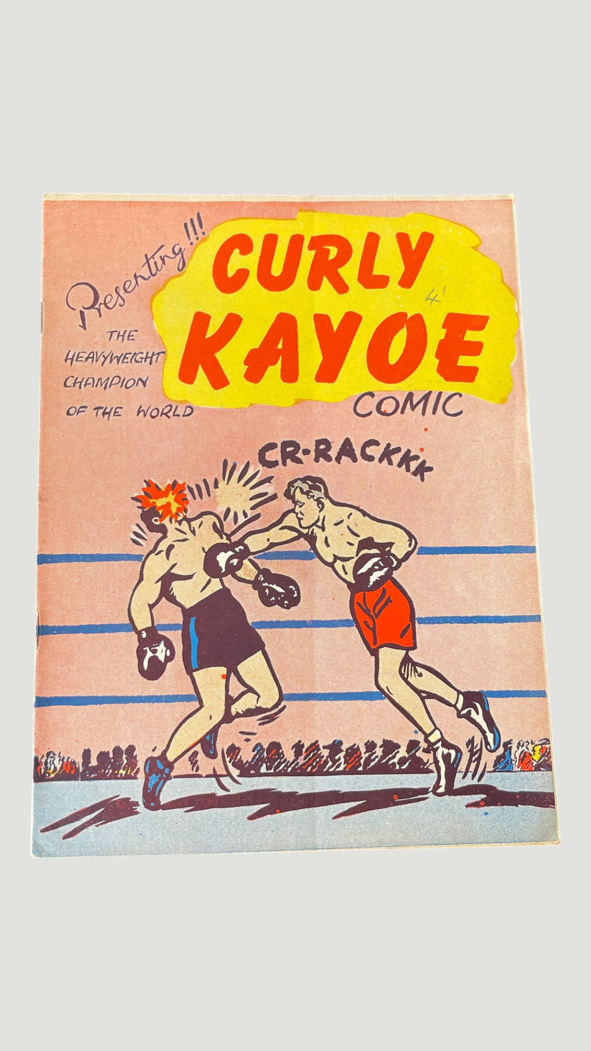 Curly Kayoe Comic 'The Heavyweight Champion of the World' Vintage Boxing Comic: A vintage copy of Curly Kayoe Comic, featuring the fictional heavyweight boxing champion Curly Kayoe. The cover art depicts a dramatic boxing ring scene with the onomatopoeic 'CR-RACKKK' sound effect,