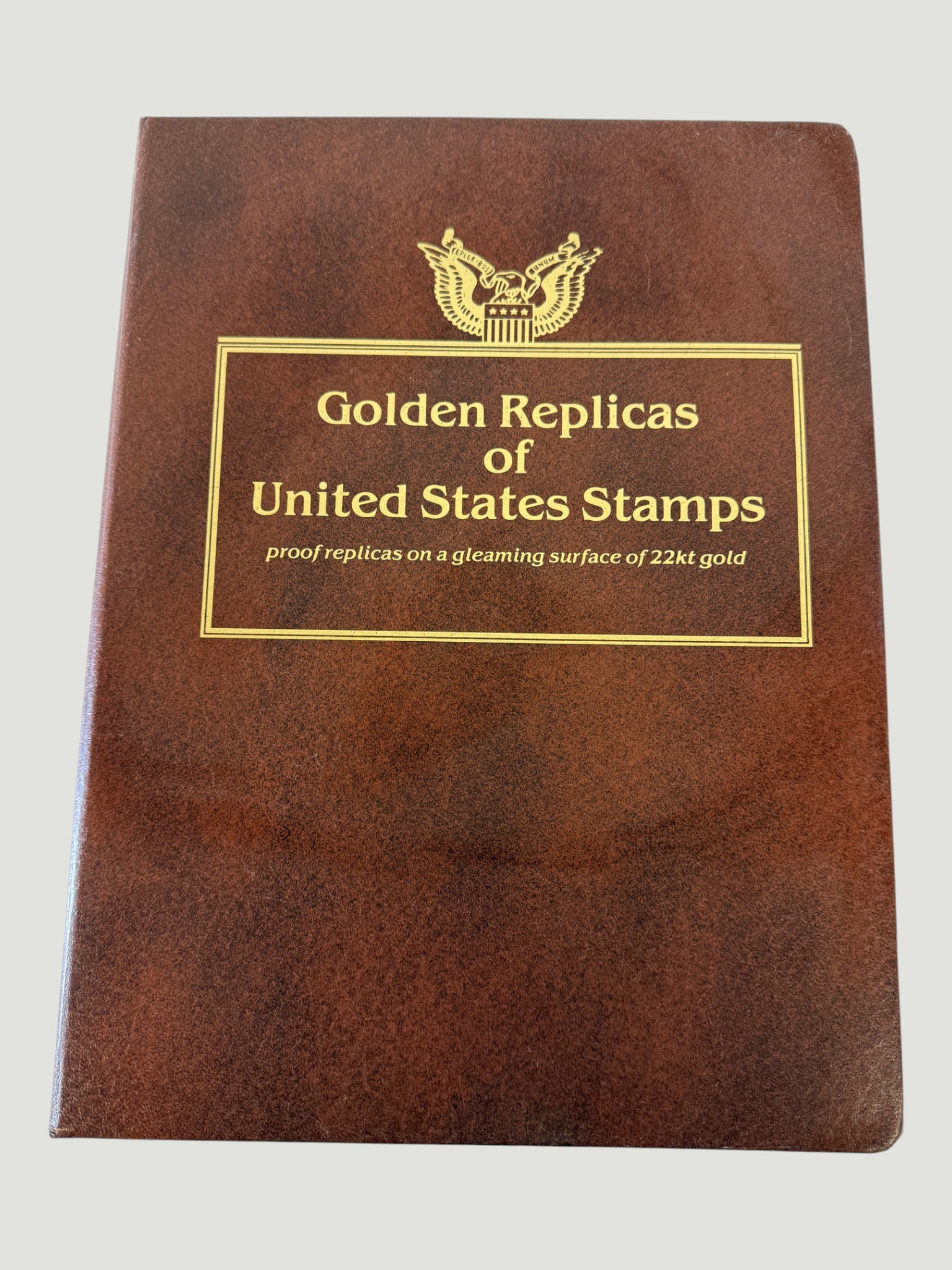 Golden Replicas of United States Stamps 22kt Gold Proof Replica Collection Album: A collector's album titled 'Golden Replicas of United States Stamps,' containing proof replicas of U.S. postage stamps reproduced on a gleaming surface of 22kt gold. These collections were produced an