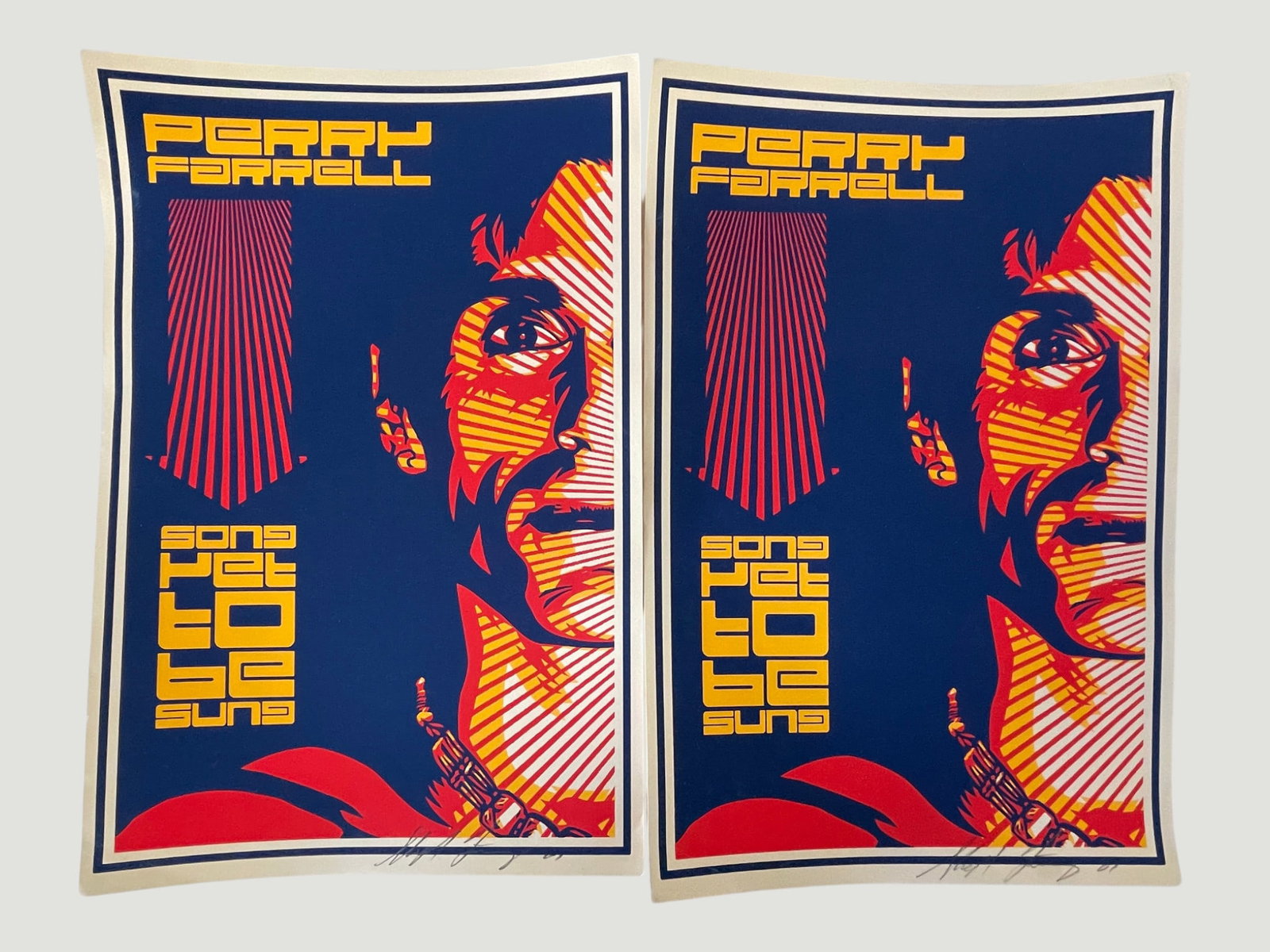 Perry Farrell 'Song Yet To Be Sung' Signed Lithograph Poster Pair (x2): A matched pair of Perry Farrell 'Song Yet To Be Sung' promotional art prints, featuring a bold propaganda-style portrait design in red, orange, yellow, and navy blue — reminiscent of Shepard Fairey'