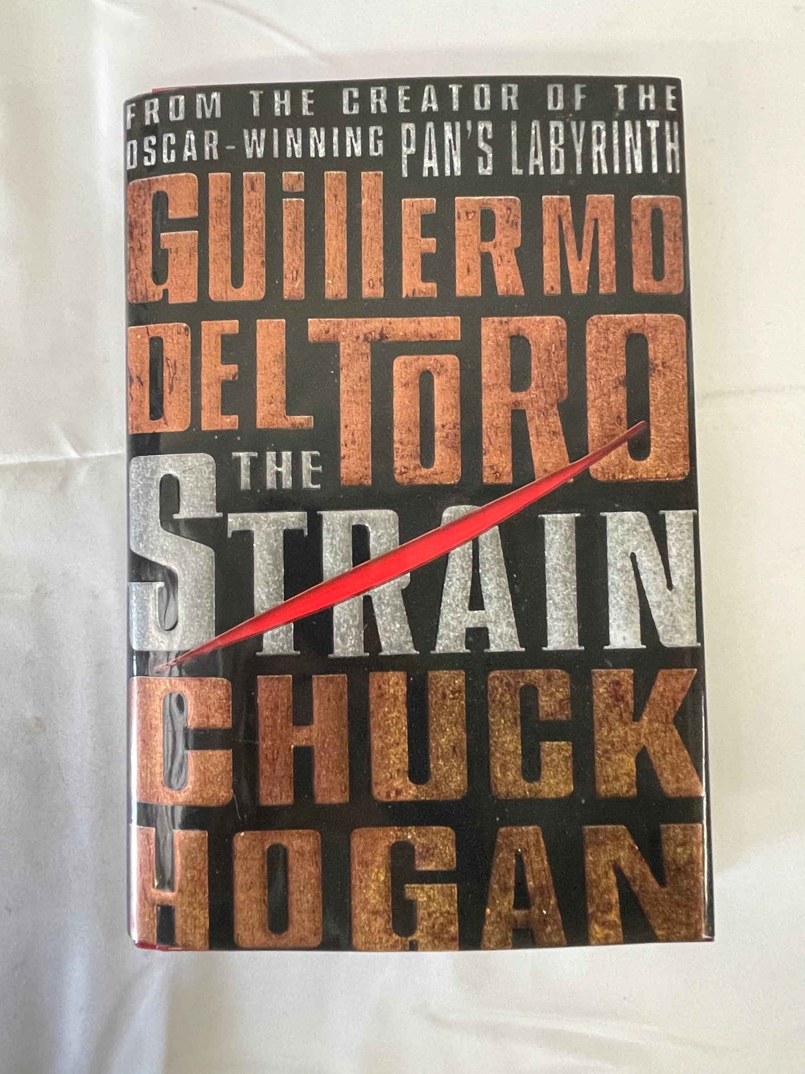 The Strain by Guillermo Del Toro & Chuck Hogan — First Edition Hardcover 2009 Signed: First edition hardcover of 'The Strain' co-authored by acclaimed filmmaker Guillermo del Toro (creator of the Oscar-winning Pan's Labyrinth) and novelist Chuck Hogan, published by William Morrow in 20