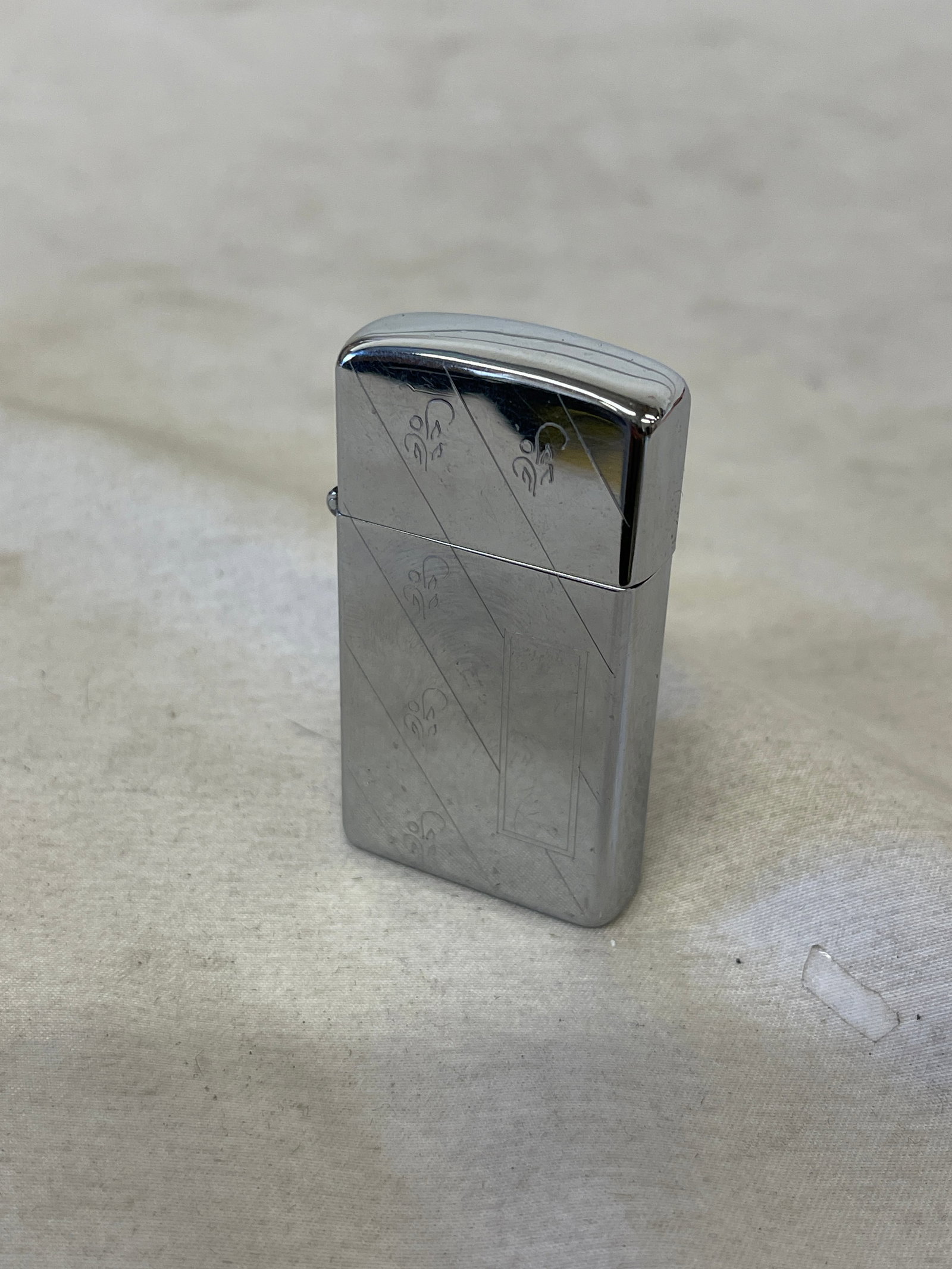 Zippo Slim Chrome Lighter with Diagonal Fleur-de-Lis Engraved Design: Zippo Slim Chrome Lighter with Diagonal Fleur-de-Lis Engraved Design