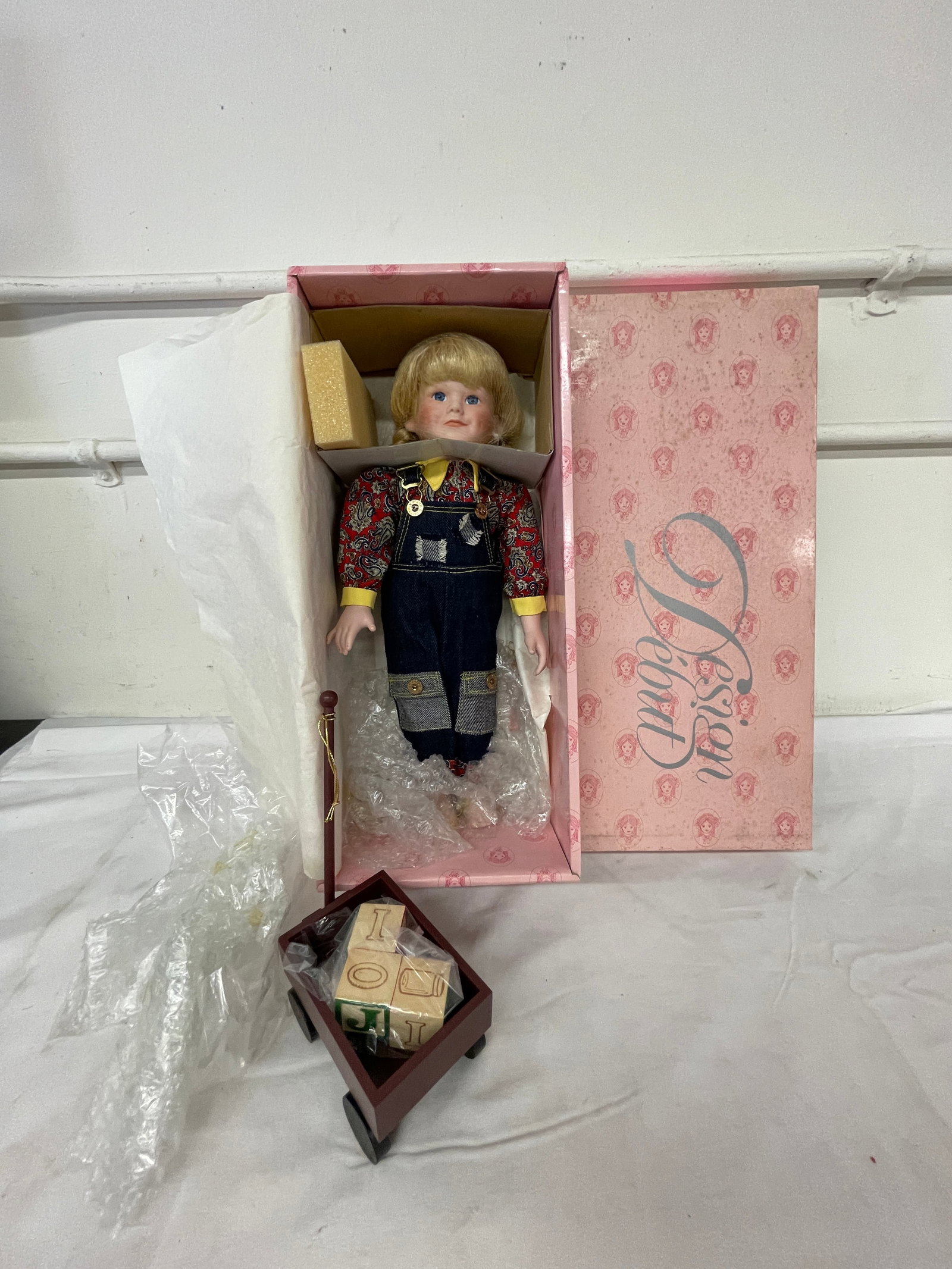 Design Debut Porcelain Girl Doll in Denim Overalls with Wooden Wagon & Blocks: Design Debut Porcelain Girl Doll in Denim Overalls with Wooden Wagon & Blocks