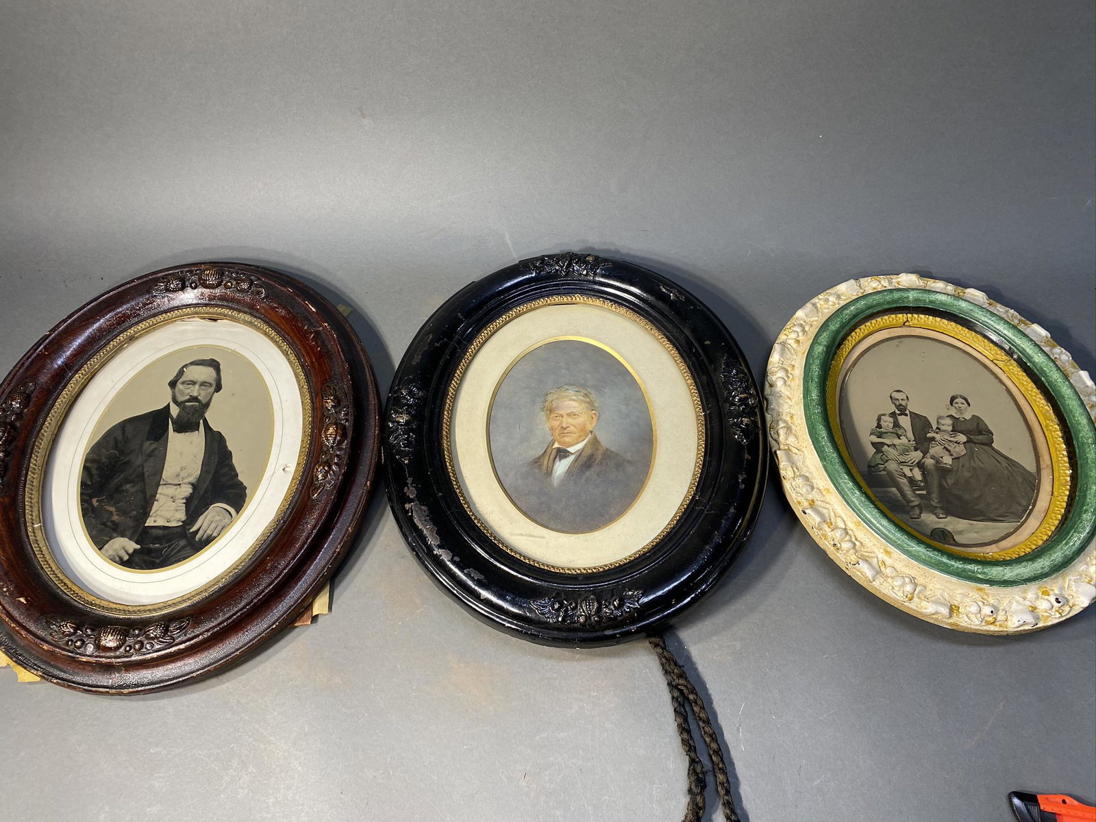 3 Early photographs in oval frames: 3 Early photographs in oval frames. From left, full plate ambrotype of a man, painted photo portrait of a man, full plate ambrotype of a family. From left, 11" x 14", 13" x 11" and 12" x 10" framed si