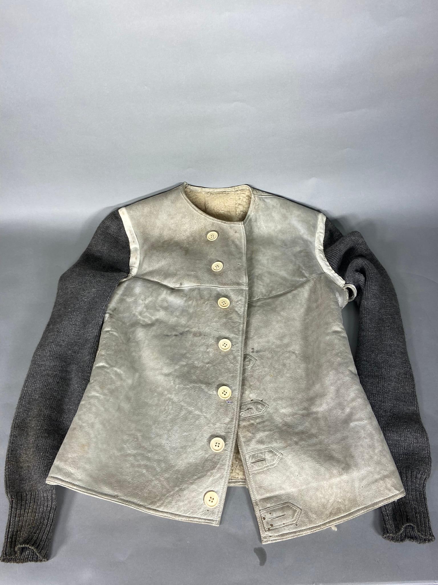 WWII NAZI GERMAN LUFTWAFFE SHEEPSKIN VEST: World War Two German sheepskin vest with wool sleeves and white buttons. Made to be worn under a flight jacket at high altitude flights. Size stampings on vest. A 4" rip at the shoulder and a repaired