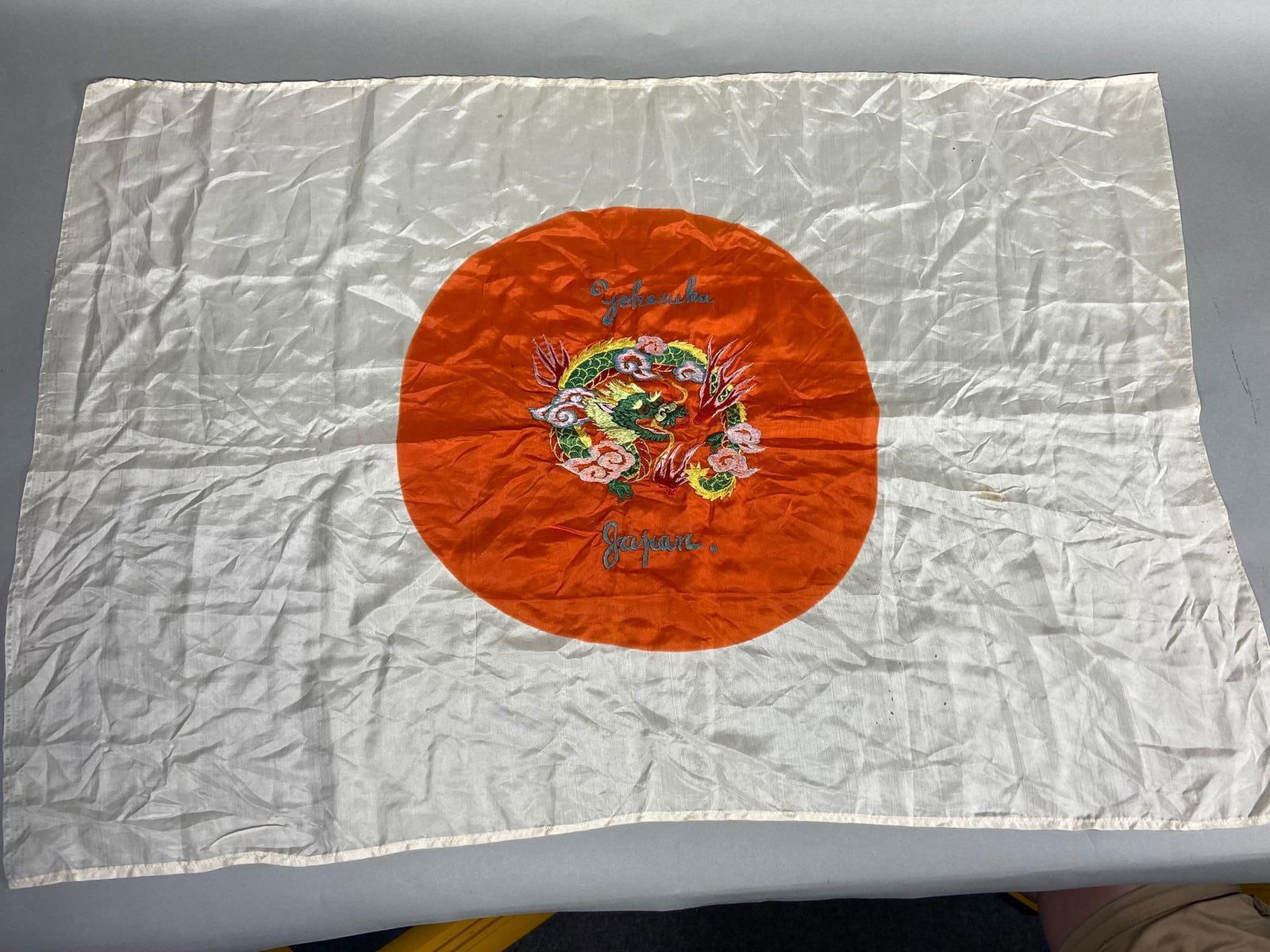 WWII JAPANESE FLAG YOKOSUKA JAPAN EMBROIDERED: World War Two Japanese meatball flag - U.S. Japanese Occupation bring back souvenir with beautiful embroidery featuring a dragon and the condition with one small stain and a few small holes. condition
