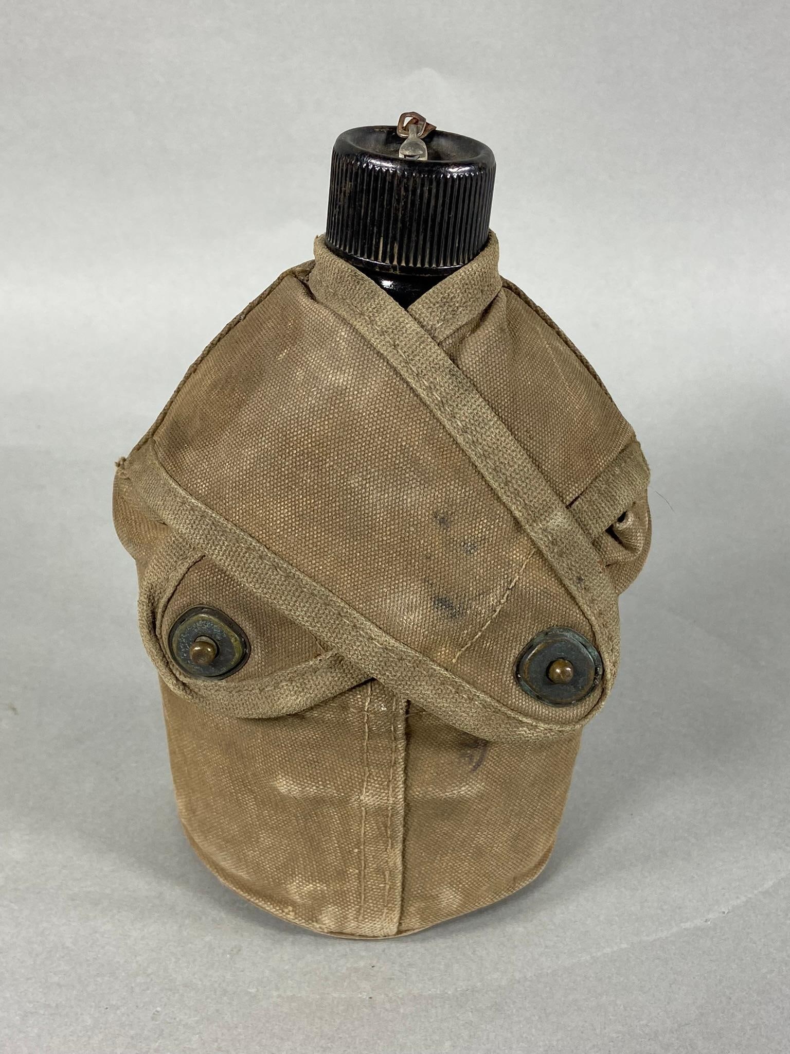 WWII 1942 BLACK ENAMEL CANTEEN USMC MARINE COVER: World War Two 1942 black enamel canteen manufacturer marked on the bottom "U.S. S.M. CO. 1942". The cup is present but is the standard issue grey metal. Canteen and cup are housed in a United States M