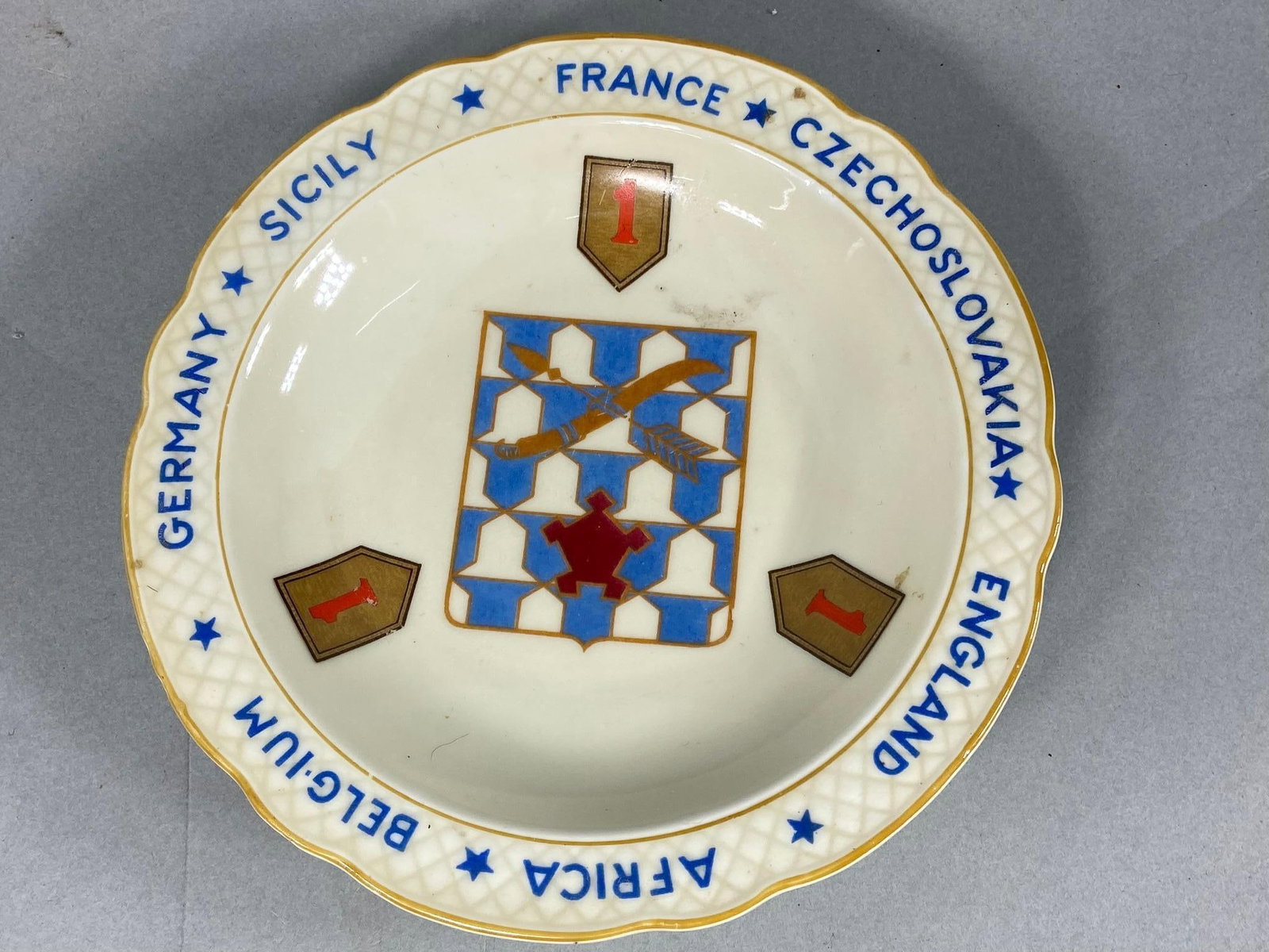 WWII 1ST DIVISION 16TH REGIMENT ASHTRAY BAVARIA: World War Two excellent condition 16th Regiment, 1st Division ashtray made in Bavaria Germany by Schumann. The ashtray features the insignia of the 16th regiment surrounded by 1st Division insignia. T