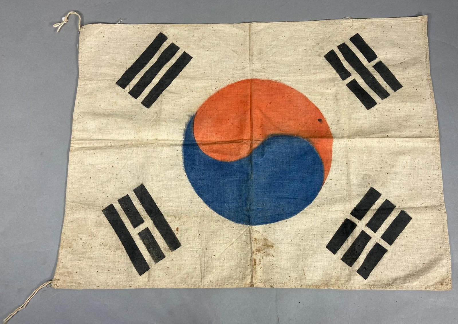 KOREAN WAR SOUTH KOREAN FLAG - KOREA: Korean War period South Korean flag made of a thick cotton material. The hoist corners feature paper reinforcement tabs. Flag measures 21 3/4" x 16 1/4". In-house shipping is available. Pickup is Thur