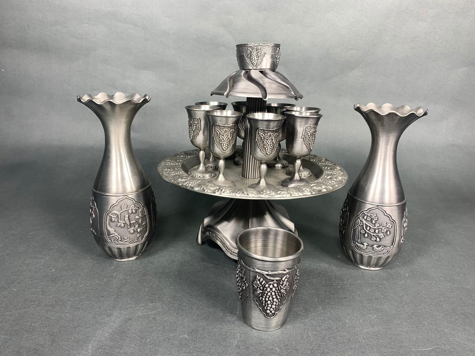 Pewter Plated Kiddush Wine Fountain with 8 Small Cups & 2 Carafes: Pewter Plated Kiddush Wine Fountain with 8 Small Cups & 2 Carafes. To see up to 100 photos of this lot, please find this sale on LiveAuctioneers. In-house shipping is available. Pickup is Friday, Apri