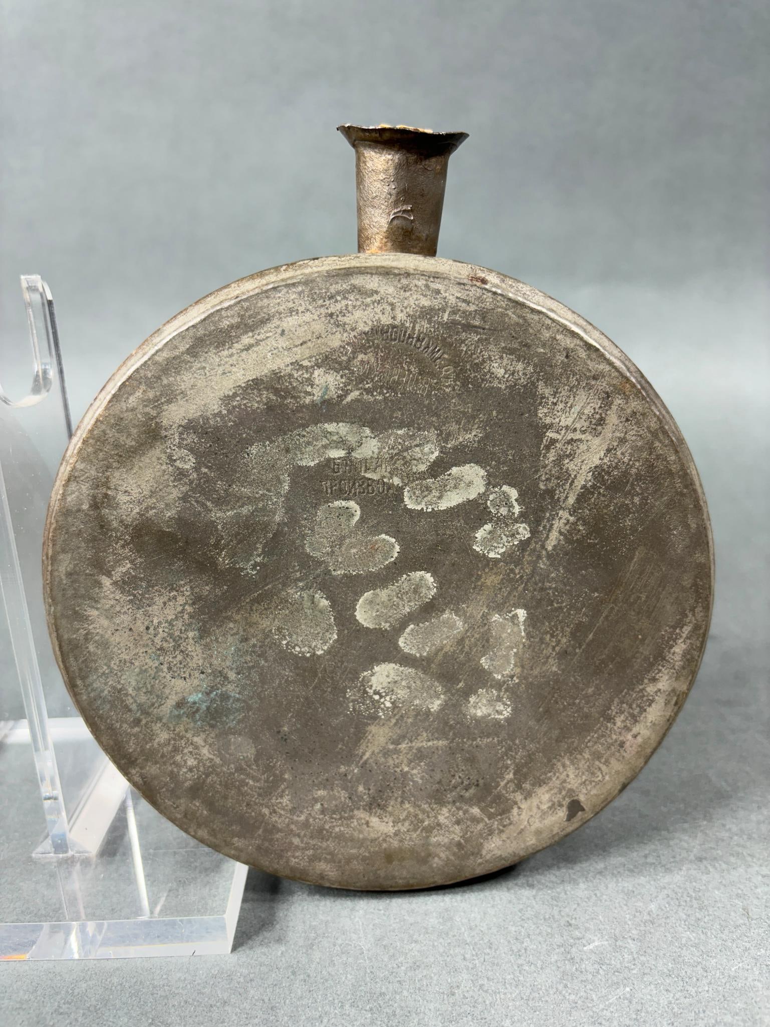 19TH CENTURY RUSSIAN TIN DRUM CANTEEN: 19th century tin drum canteen of Russian origin.Canteen has cyrillic lettering and still retains remnants of a cork stopper. Width is 2.75". Diameter is 6.625". In-house shipping is available. Pickup