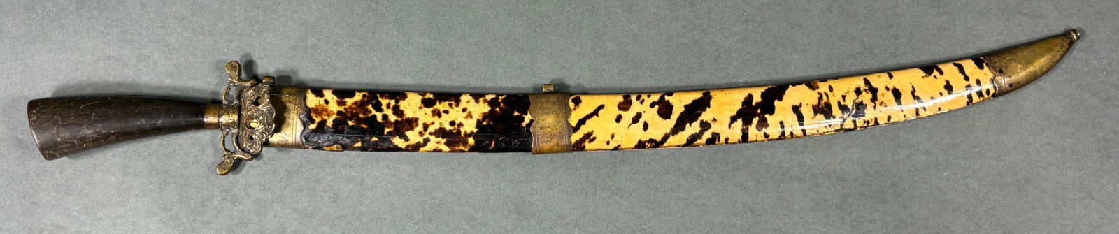 19TH CENT. CHINESE DAGGER TORTOISE SHELL SHEATH: 19th century Chinese dagger with a tortoise shell sheath. Dagger features a wood handle and floral pattern brass guard and pommel cap. Slightly curved blade has a few nicks near the tip. The sheath is