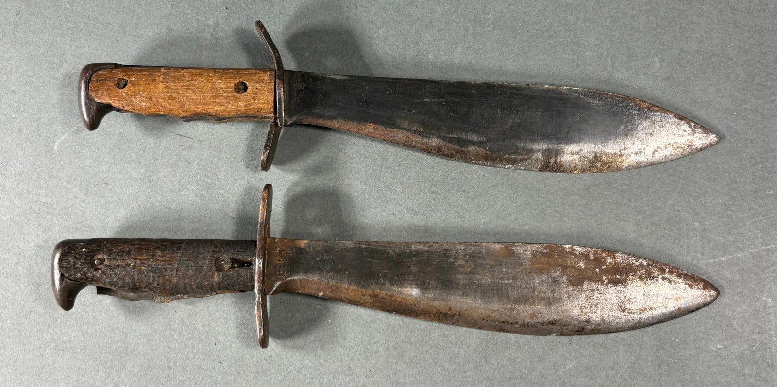 WWI U.S. M1917 BOLO KNIFE LOT (2): World War One M 1917 bolo knife lot consisting of two bolo knives both manufactured by Plumb, St. Louis, Missouri and dated 1918. Both are in fair condition with one having a cross guard that is damag