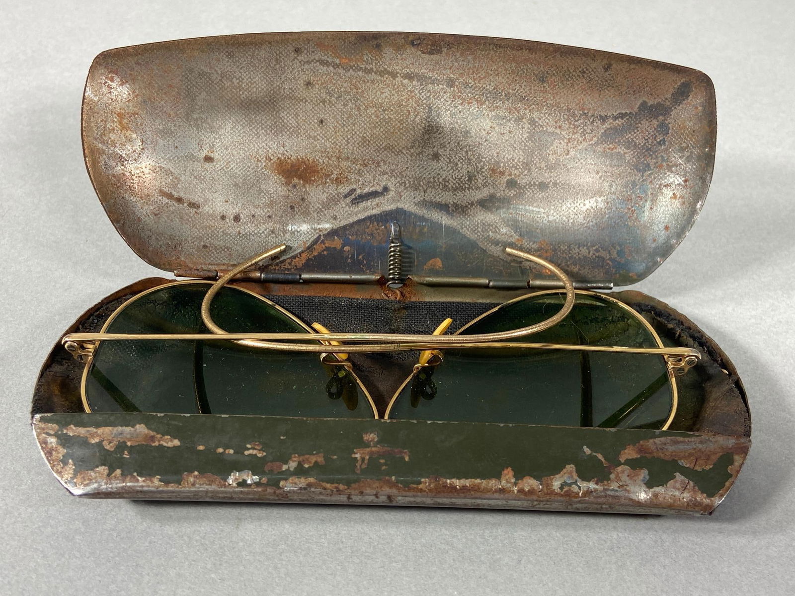 WWII AAF BAUSCH & LOMB RAY BAN AVIATOR SUNGLASSES 1/10 12K GOLD FILLED: World War Two United States Army Air Force U.S.AAF Bausch & Lomb RAY BAN bullet hole 1/10 12K gold filled aviator sunglasses in a tin case that still retains remnants of OD green paint. Stamped on the