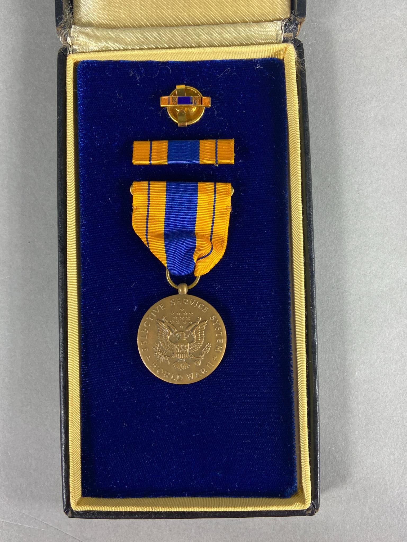 WWII CASED US SELECTIVE SERVICE MEDAL SLOT BROOCH: World War Two cased slot brooch Selective Service Medal, ribbon bar, and lapel pin. In-house shipping is available. Pickup is Monday, April 29th from 11 am to 3 pm in Carroll, Ohio 43112 or we will pr
