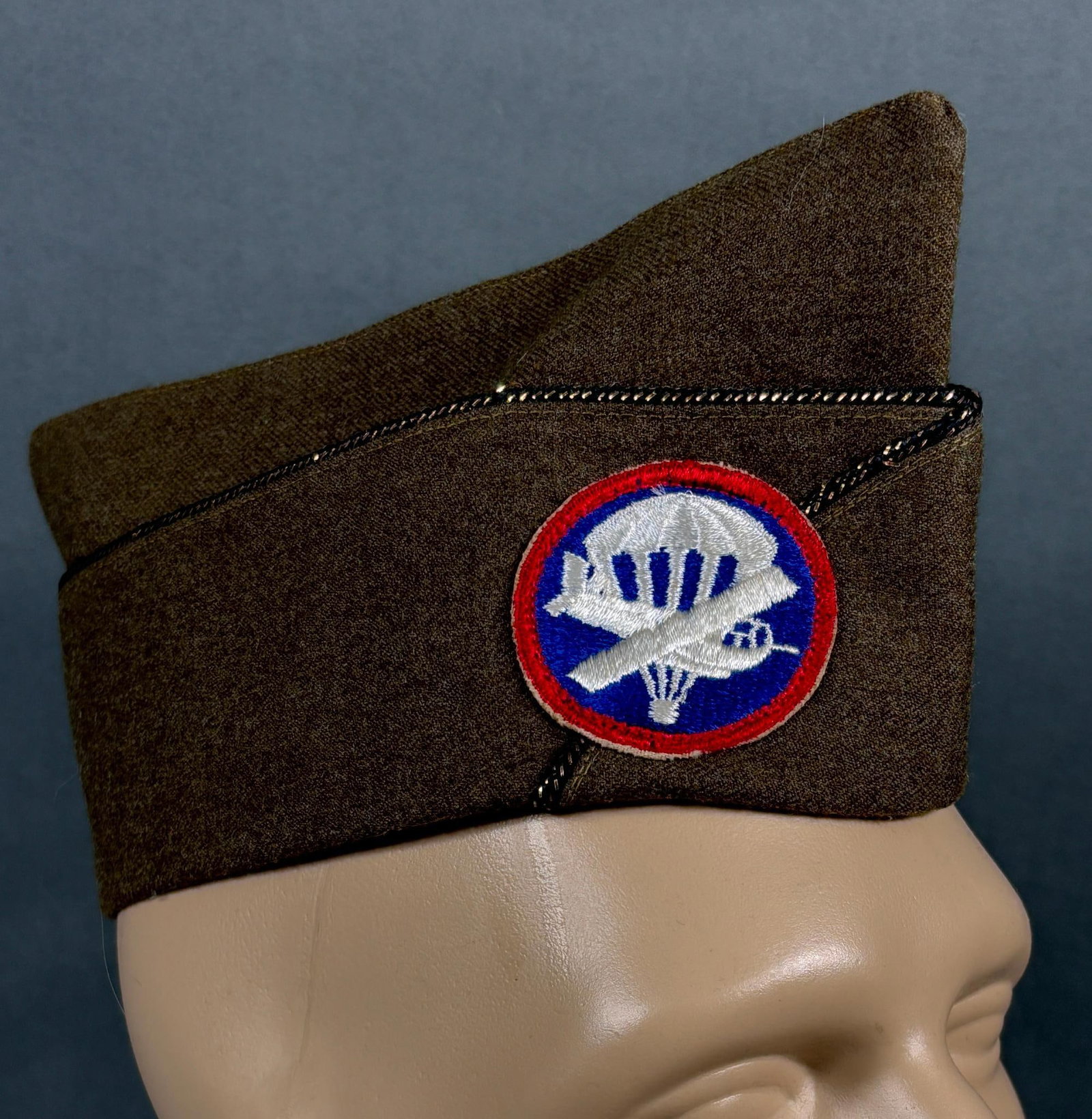 WWII AIRBORNE IDED OFFICER'S GARRISON CAP W/ PATCH: World War Two airborne paratrooper officer's wool garrison cap with right facing officer cap patch. The name "HARDY" is stenciled under the leather sweatband. The cap measures 2.25" in diameter. Patch