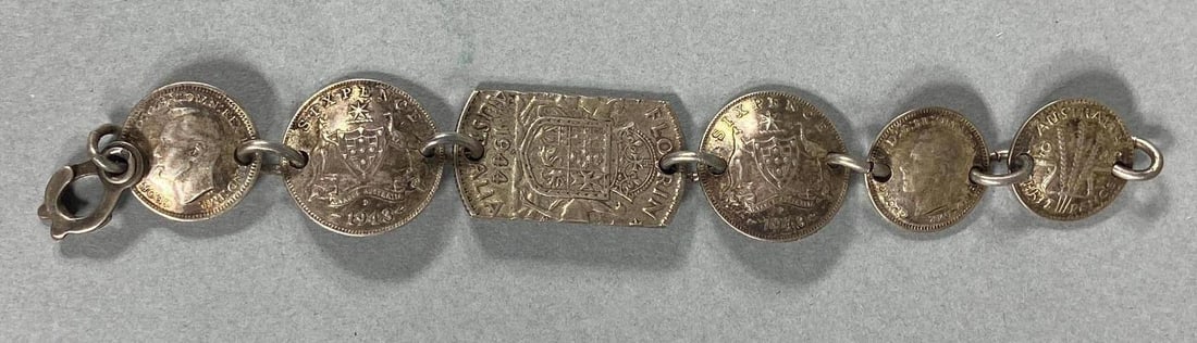 WWII TRENCH ART BRACELET AUSTRALIAN SILVER COINS: World War Two Australia souvenir - trench art bracelet fashioned from 1943 & 1944 dated Australian coins. Two of the coins feature a bust of King George VI. Bracelet measures approx. 6". In-house ship