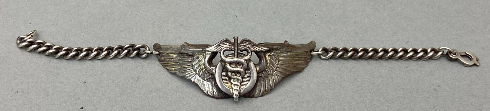 WWII AAF STERLING FLIGHT SURGEON WINGS - BRACELET: World War Two U.S. Army Air Forces 3.25" sterling silver flight surgeon wings that were fashioned into a trench art bracelet. The "sterling" stamping, while still visible, was partially obliterated wh