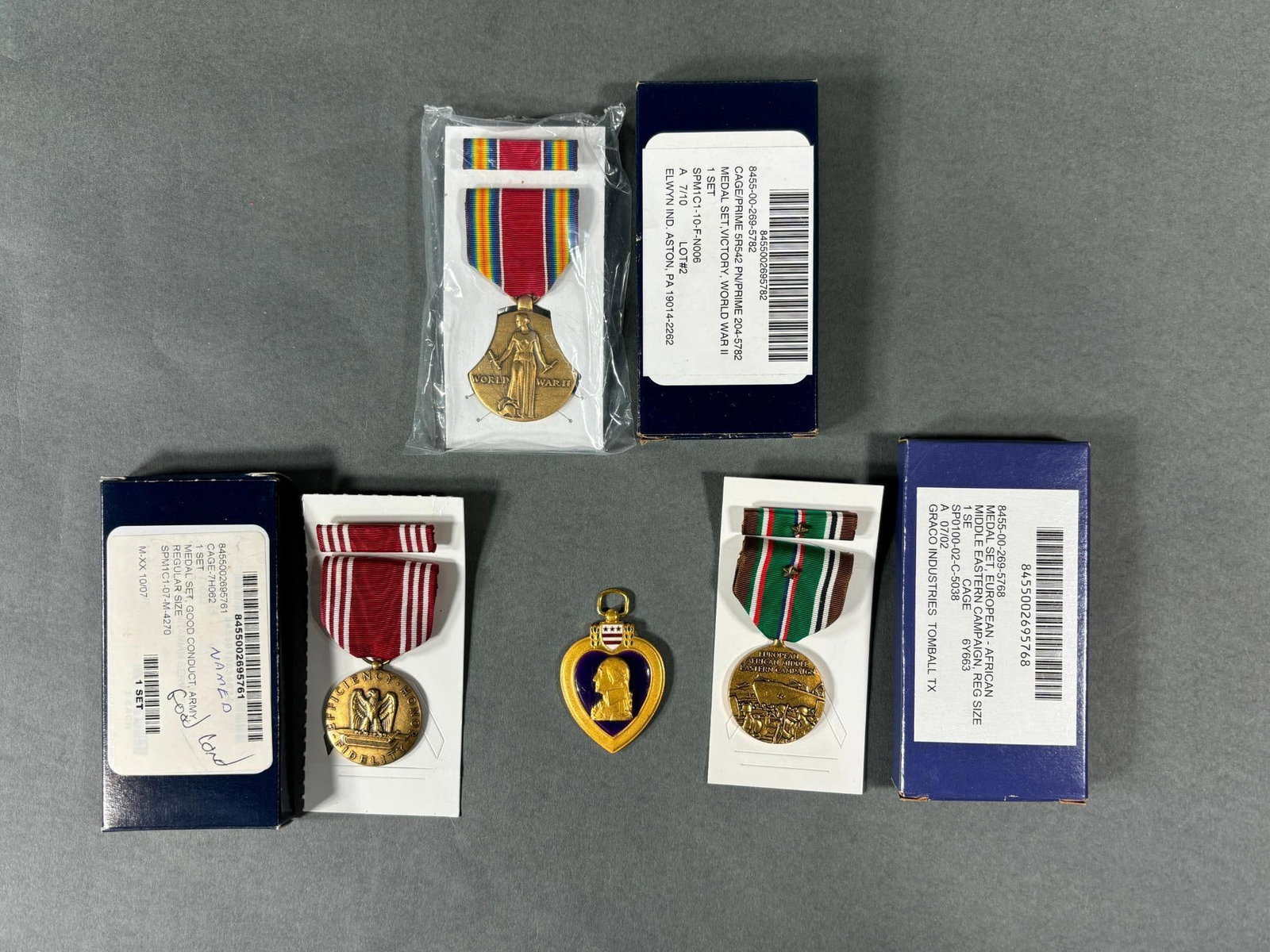 WWII IDED PURPLE HEART PLUS VET'S REISSUED MEDALS: Original World War Two WIA Purple Heart (only the drop) with modern reissued Good Conduct, Victory, and ETO medals that are engraved to Fred Tadrous of Brecksville, Ohio. A copy of his obituary is inc
