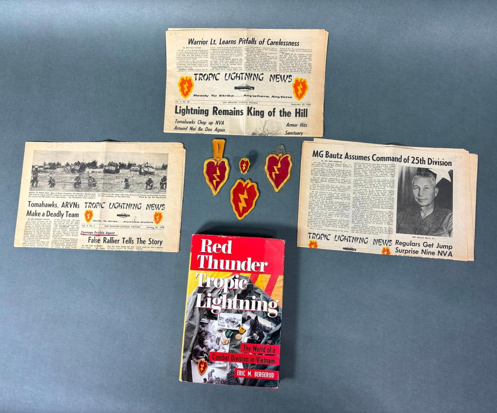 VIETNAM 25TH DIV THEATER MADE DI PATCH NEWSPAPER: Vietnam War 25th Division lot including a theater made 'beercan" DI, two theater made pocket patches, a U.S. made shoulder patch, three "Tropic Lightning News" newspapers dated from 1969 and 1970, and