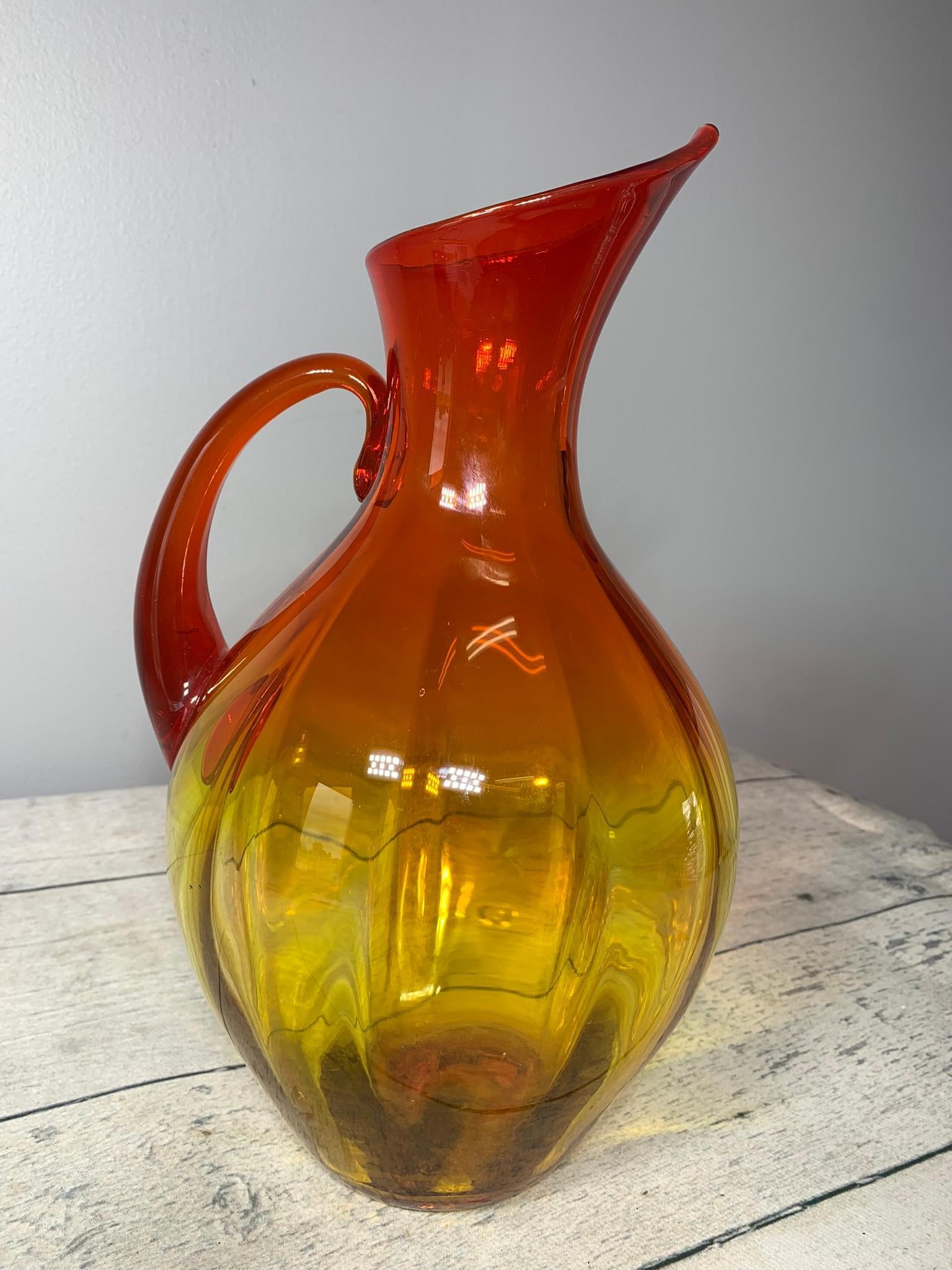 Blenko Art Glass Pitcher Amberina: Manufacture Inclusion by Handle Pictured. In-house shipping is available. Pickup is Tuesday, June 4th from 1 pm to 7 pm and Wednesday, June 5 from 11 am to 3 pm at our offices in Carroll, OH 43112 or 