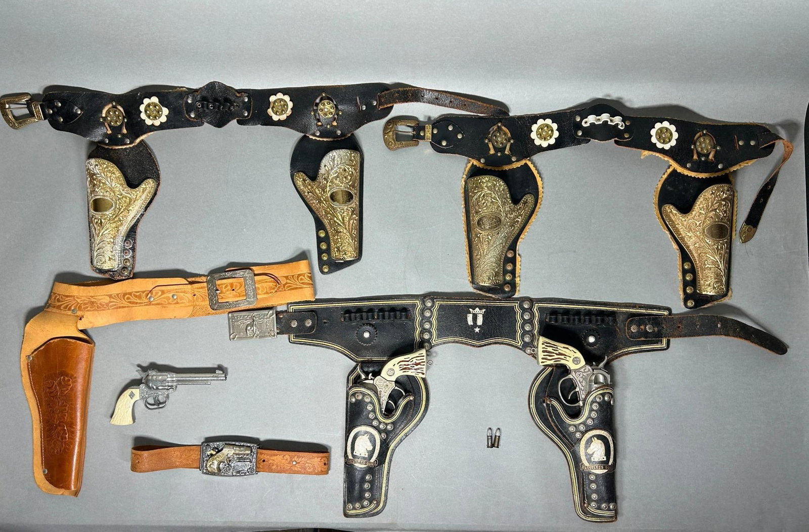 1950's -60s Lot Toy Cap Gun & holster sets - Mattel - ACTOY etc.: Lot of vintage 1950s - 60s Western cowboy toy guns and holsters. Condition very good with wear as seen in photos. 1. 1959 Mattel Agent Zero derringer belt buckle complete with buckle, derringer, bulle