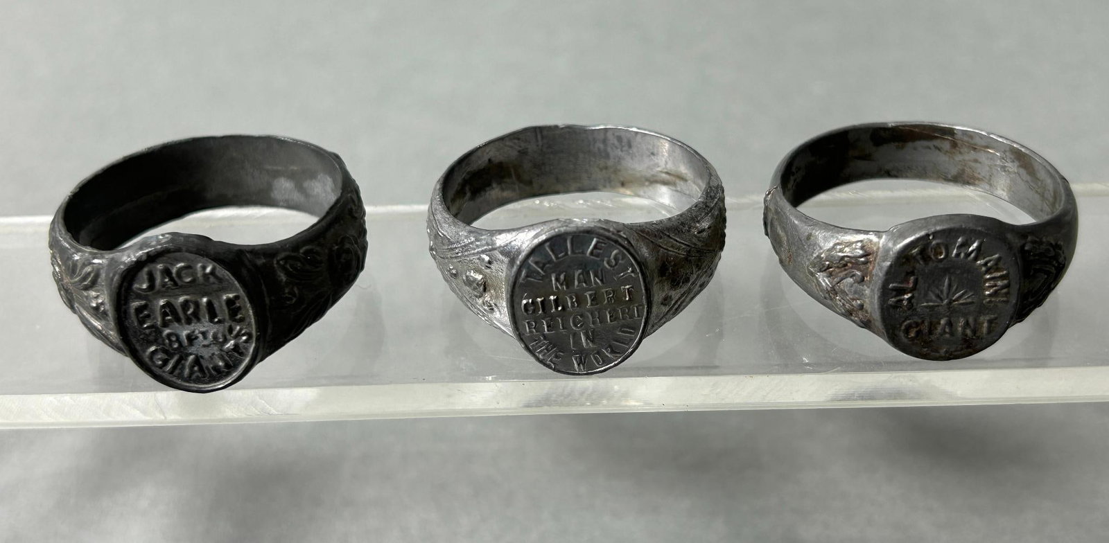 Circus Giant Ring lot - Jack Earle, Gilbert Reichert, Al Tomaini: Circus Giant rings from JACK EARLE, GILBERT REICHERT, and AL TOMAINI. All three rings are approx. 1.25" in diameter and are Gray/silver metal. These are souvenir rings that were sold by the "giants" a