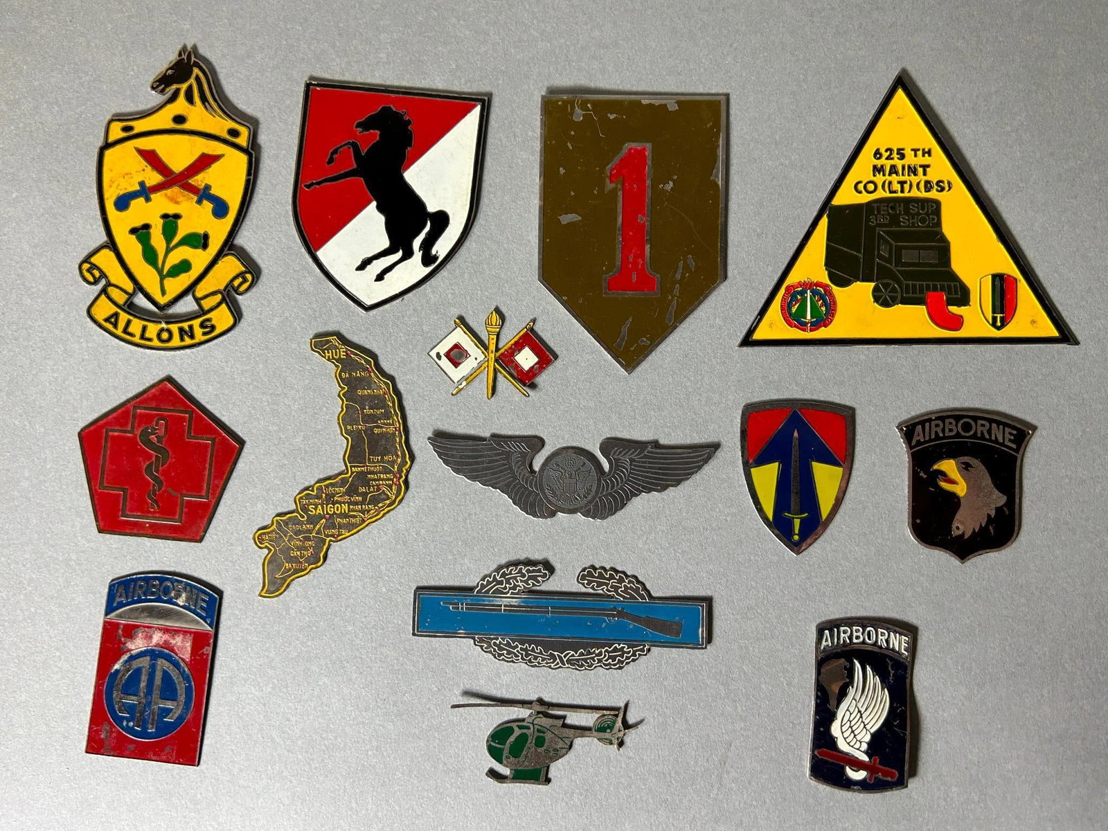Vietnam War Theater Made Beer Can Plaque Insignia Lot: 13 Vietnam theater made beer can plaque insignia lot. Included are; CIB badge, 173rd Airborne, 101st Airborne, 82nd Airborne, 625th Maintenance Company, 1st Division, Air Force pilot wings, 11th Armor