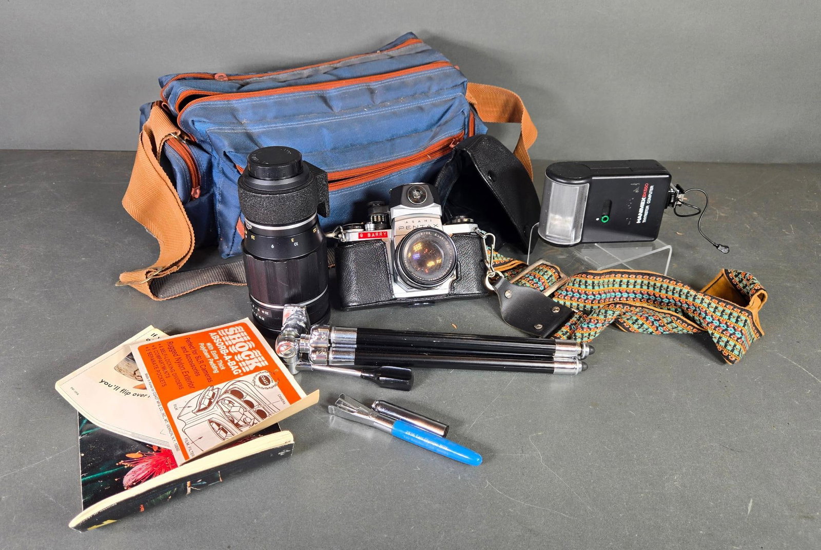 Vintage Pentax Camera, Asahi Optical Co. Lens, Flash, Tripod and Camera Bag: Bag has broken zippers. In-house shipping available. Pickup is Thursday, May 29 from from 1 pm to 7 pm at our gallery in Lancaster, OH 43130 or we will provide in-house shipping for this item. We char