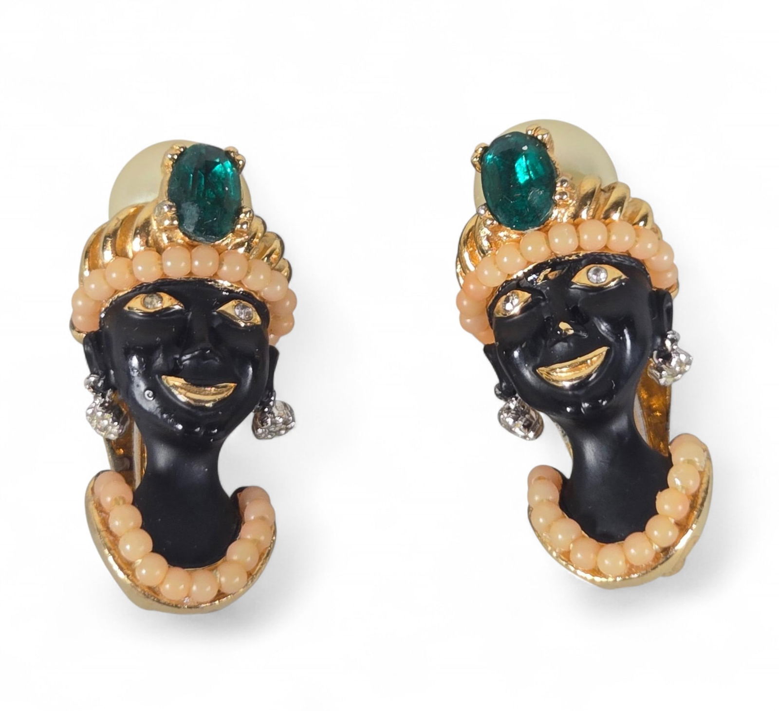 CINER Figural Blackamoor Clip-On Earrings - Black Enamel, Gold Tone, Green Stones, Faux Pearls: This pair of CINER clip-on earrings features a figural design, depicting faces crafted from black enamel. The figures are adorned with gold-tone accents, green cabochon-style stones, peach-colored bea
