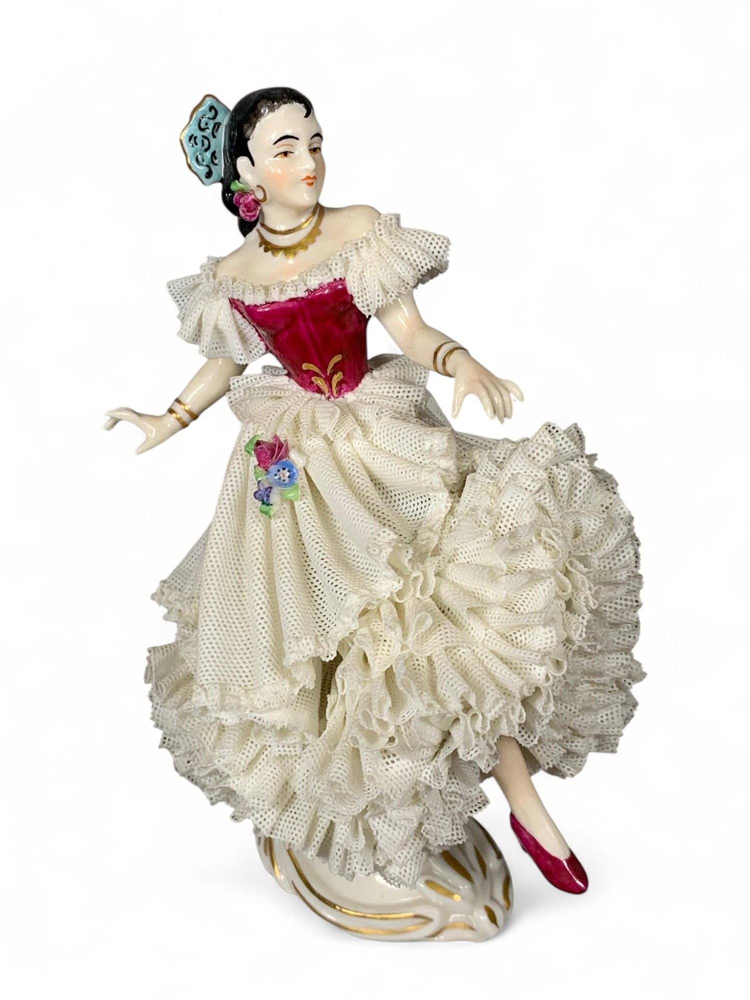 Porcelain Dancer Figurine - White Lace Ruffles, Red Bodice, Hand-painted Details: This elegant porcelain figurine depicts a female dancer adorned in a flowing white dress with intricate lace ruffle details and a vibrant red bodice. The figure features delicate hand-painted facial f