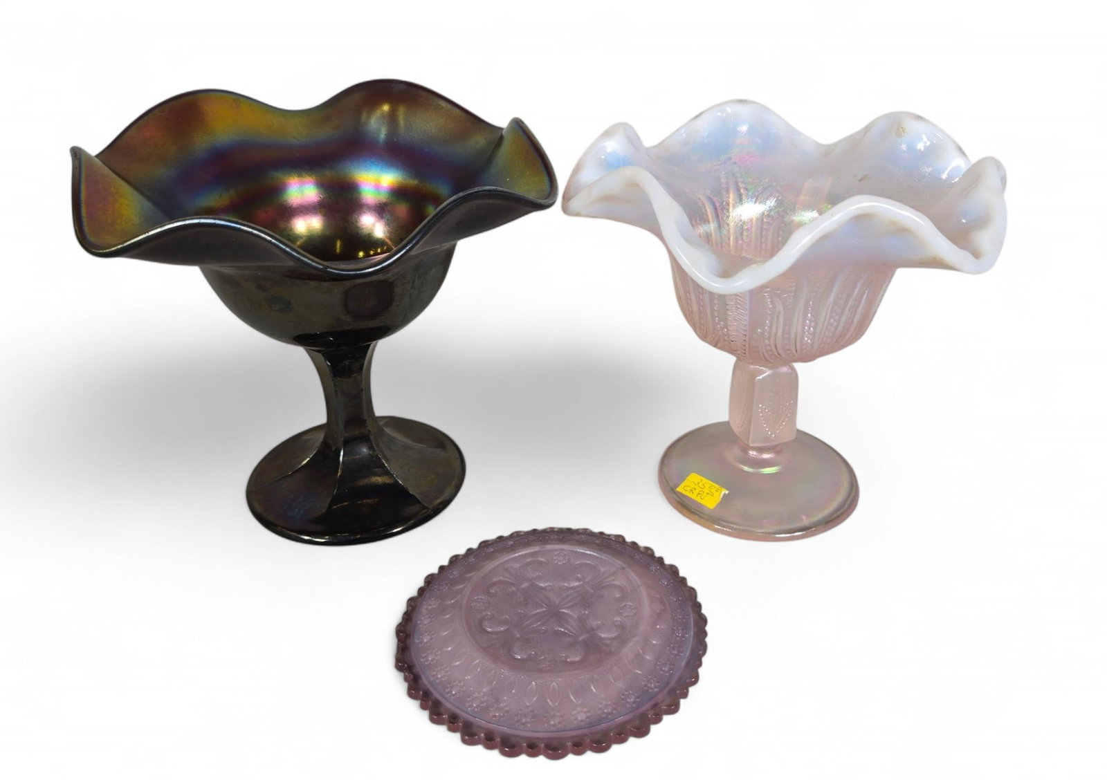 Carnival Glass Compote Bowls and Plate - Iridescent, Ruffled Edge, Scalloped, Multi-color: This lot features three pieces of decorative glass. The first is a dark iridescent glass footed compote bowl with a ruffled rim, exhibiting rich purple, green, and gold hues. The second item is a pink