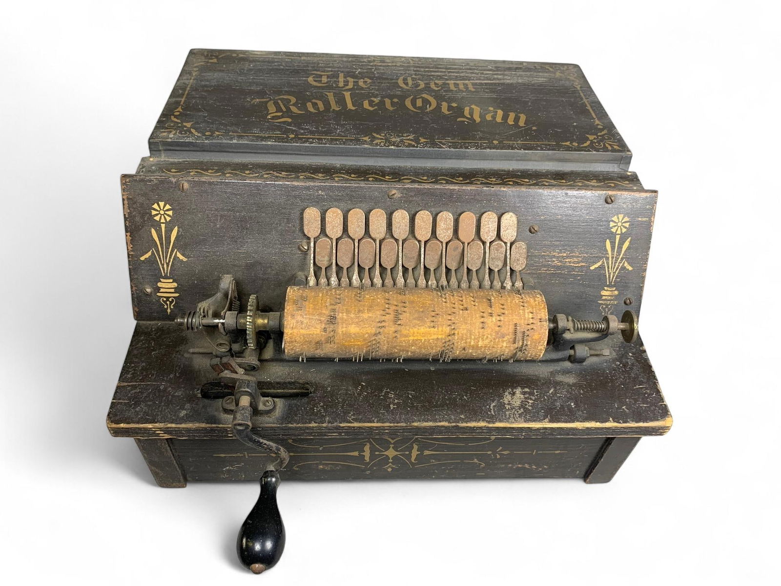 Antique "The Gem" Roller Organ, Late 19th/Early 20th Century: An antique "The Gem" Roller Organ, constructed primarily from dark-stained wood. The instrument features an exposed pinned wooden music cylinder, a series of metal strikers or reeds, and a hand crank