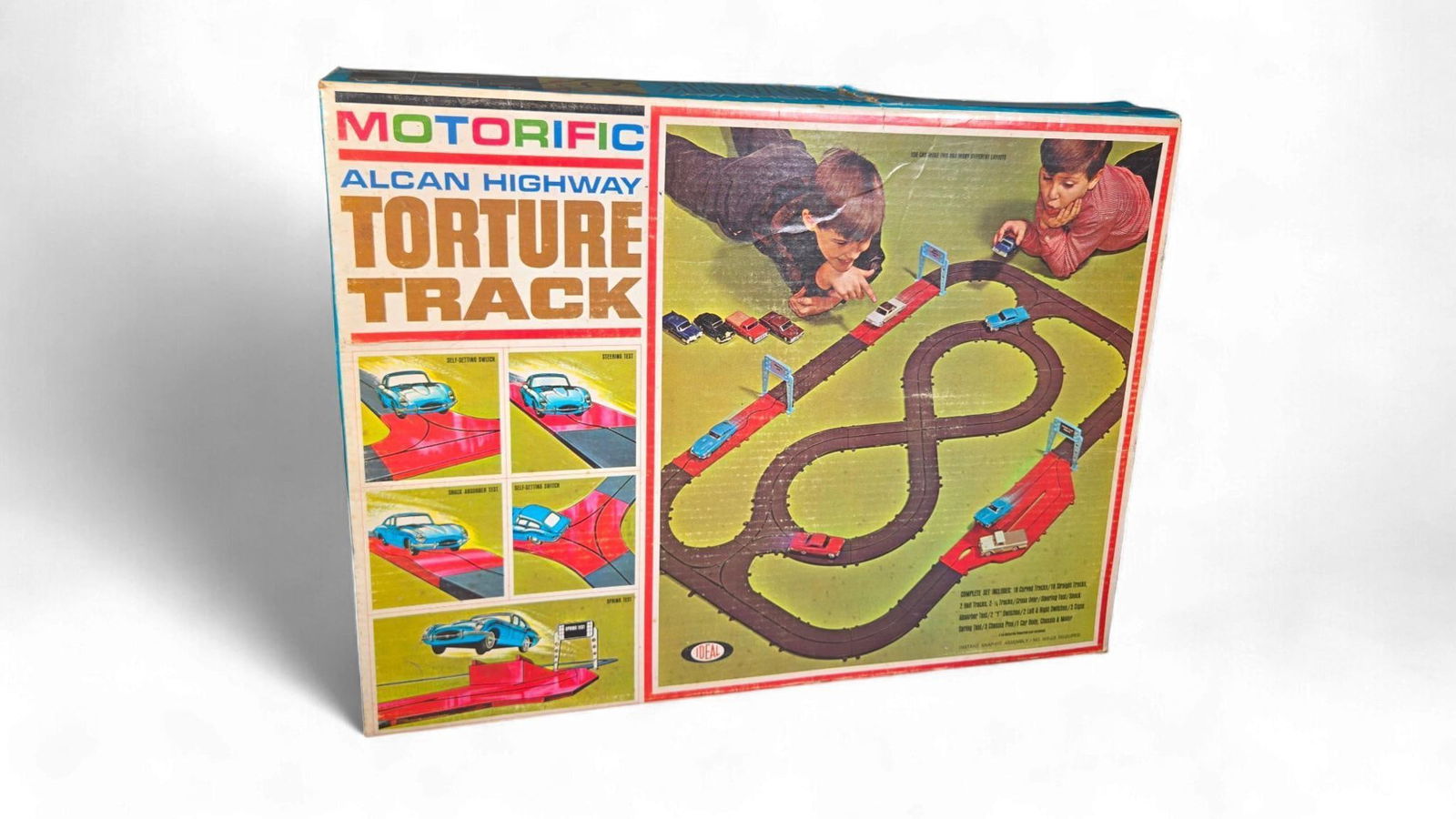 Ideal Motorific Alcan Highway Torture Track Set, circa 1965: A vintage Ideal Motorific Alcan Highway Torture Track Set, dating to approximately 1965. The primary set is housed in its original cardboard box, which depicts various track configurations and childre