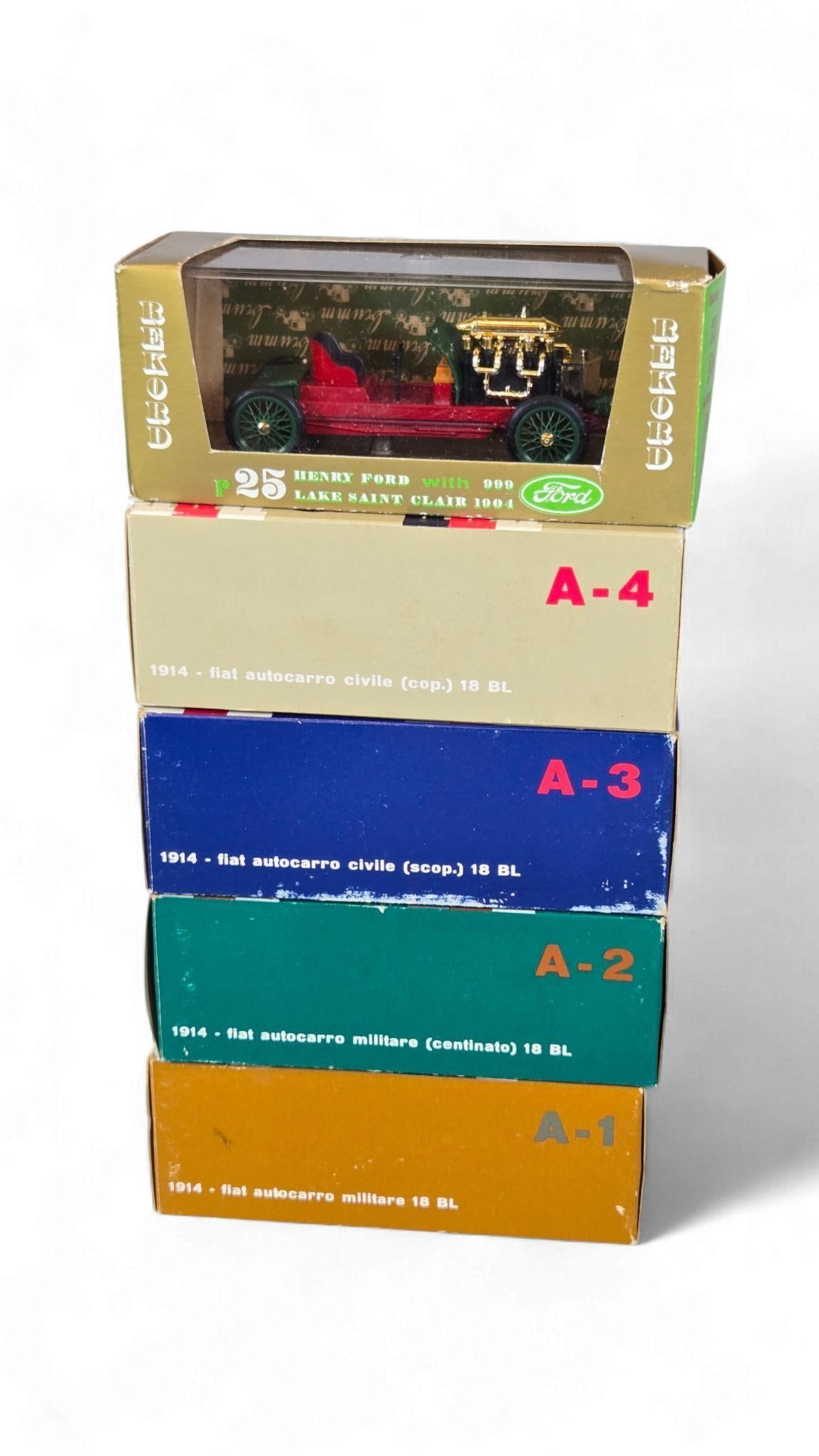 A Group of Vintage-Style diecast Vehicle Models, including Rekord Henry Ford and Fiat 18 BL Trucks: A Group of vintage-style diecast vehicle models, each presented within its original cardboard packaging featuring a clear plastic window. The uppermost model, from the "REKORD" series, is identified a