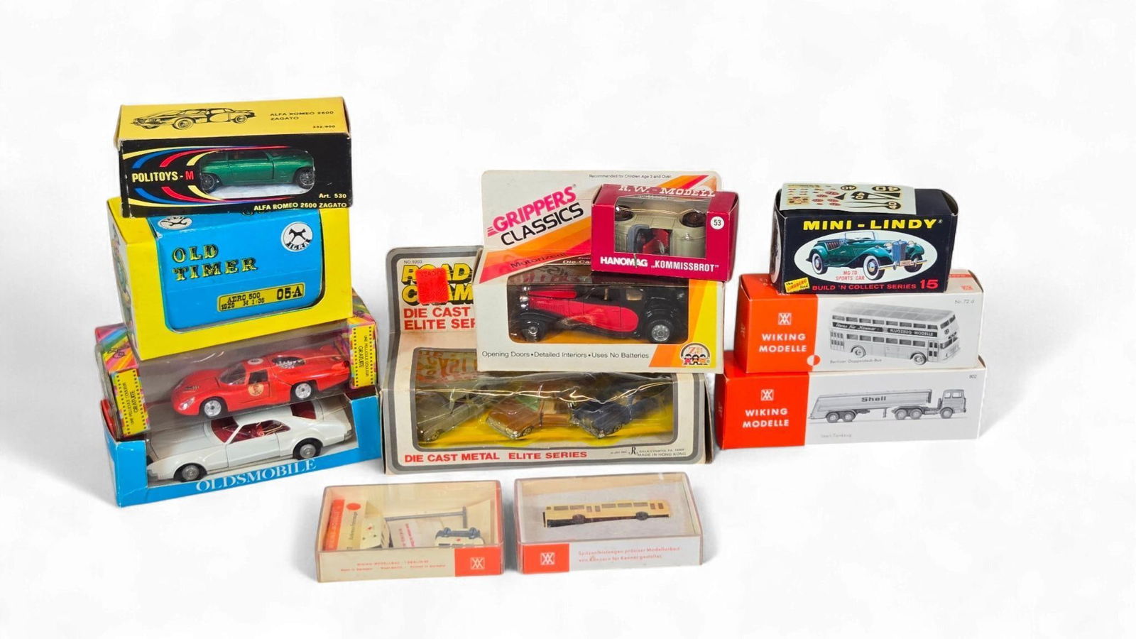 A Group of Vintage and Modern diecast and Plastic Model Vehicles: A diverse collection of vintage and modern diecast and plastic model vehicles, primarily from the 20th century. The collection includes cars, buses, and trucks from various manufacturers such as Lindb