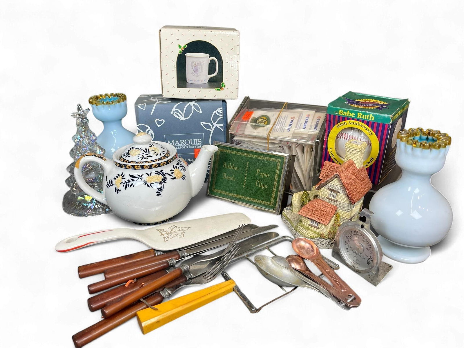 A Diverse Collection of Kitchenware, Decorative Objects, and Collectibles, including a Vintage Ceram: This diverse lot comprises various kitchenware, decorative objects, and collectibles. Kitchen items include a vintage white ceramic pie server with a gold maple leaf design and red handle accents. Als