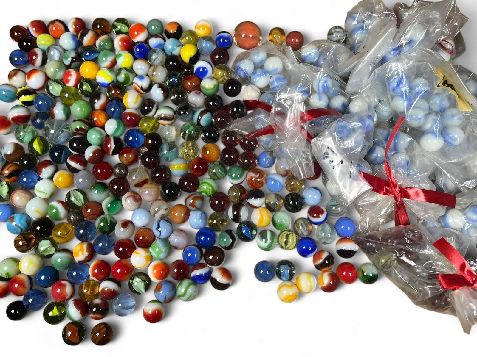 A Large Collection of Assorted Glass Marbles, including UV-Reactive Examples: A substantial collection of glass marbles, showcasing a diverse range of styles including solid, swirled, transparent, opaque, and cat's eye designs in various colors. A significant portion of these m