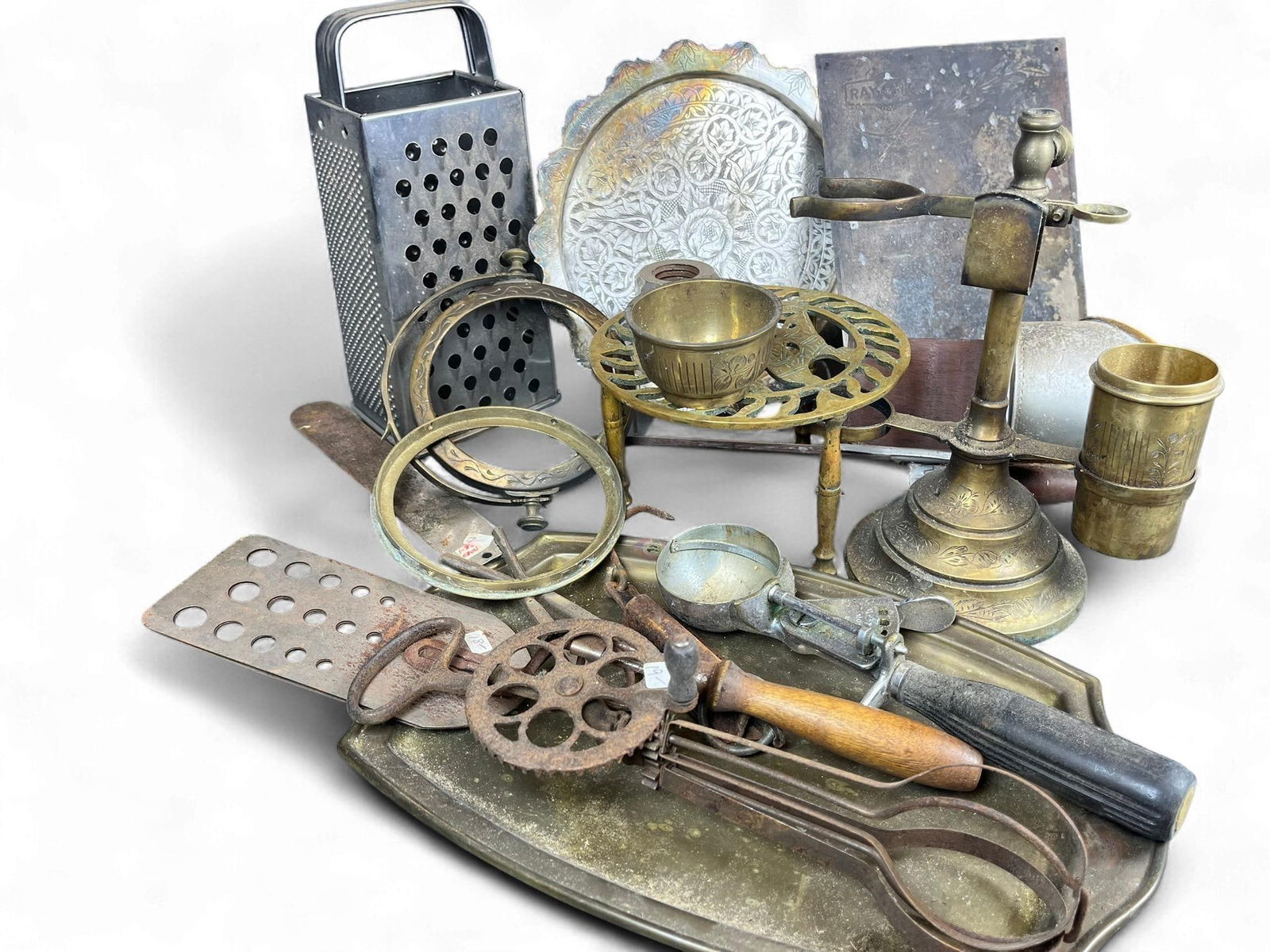 A Collection of Vintage and Antique Metalware, including Manning-Bowman & Co. Tray, J.H. Sternbergh : A diverse collection of vintage and antique metalware, comprising kitchen utensils, decorative objects, and advertising pieces. Key items include a brass candle snuffer stand featuring an etched flora