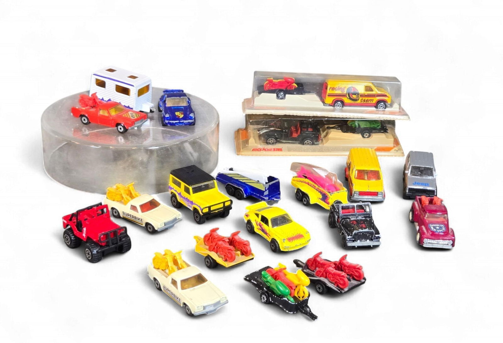 A Collection of Vintage Matchbox, Majorette, and Hot Wheels diecast Vehicles, including a 1981 Match: A collection of approximately 20-25 miniature diecast toy vehicles and accompanying trailers, predominantly manufactured by Matchbox, Majorette, and Hot Wheels. Copyright dates visible on the items ra