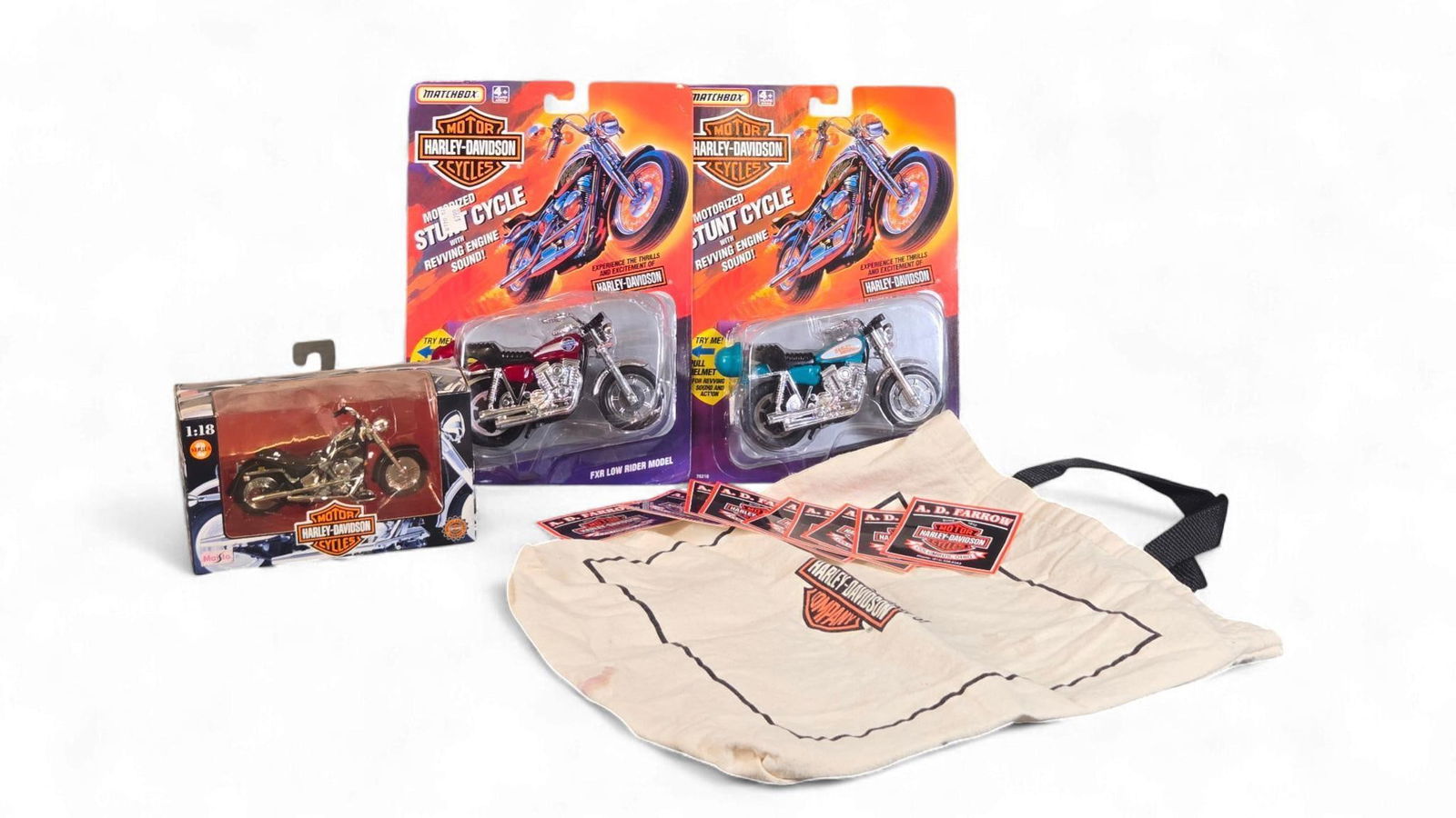 A Collection of Harley-Davidson Model Motorcycles and Memorabilia: This lot features a collection of Harley-Davidson branded merchandise. It includes diecast model motorcycles: two Matchbox "Motorized Stunt Cycle" FXR Low Rider models, one in red and one in teal, bot