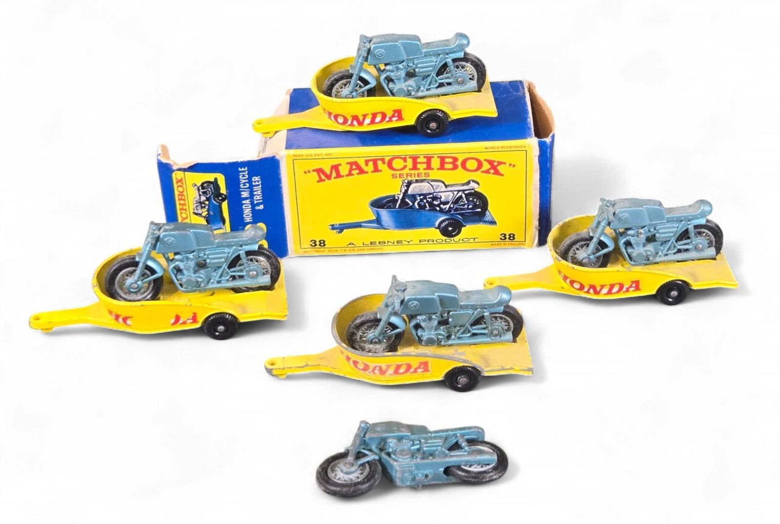 A Group of Matchbox Lesney No. 38 Honda Motorcycle & Trailer Sets: A group of Matchbox Lesney No. 38 Honda Motorcycle & Trailer sets, comprising five complete motorcycle and trailer sets, and one additional loose motorcycle. Each set features a light blue diecast mot