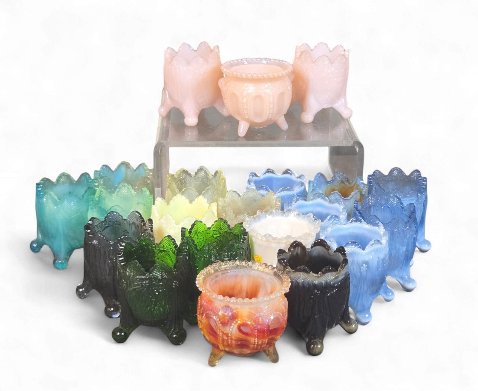 A Group of Victorian and Early 20th Century Pressed Glass Salt Cellars, Toothpick Holders, and Rose : This extensive collection comprises small, footed opalescent glass vessels, characteristic of Victorian or early 20th-century pressed glass manufacture. The forms primarily resemble salt cellars or ma