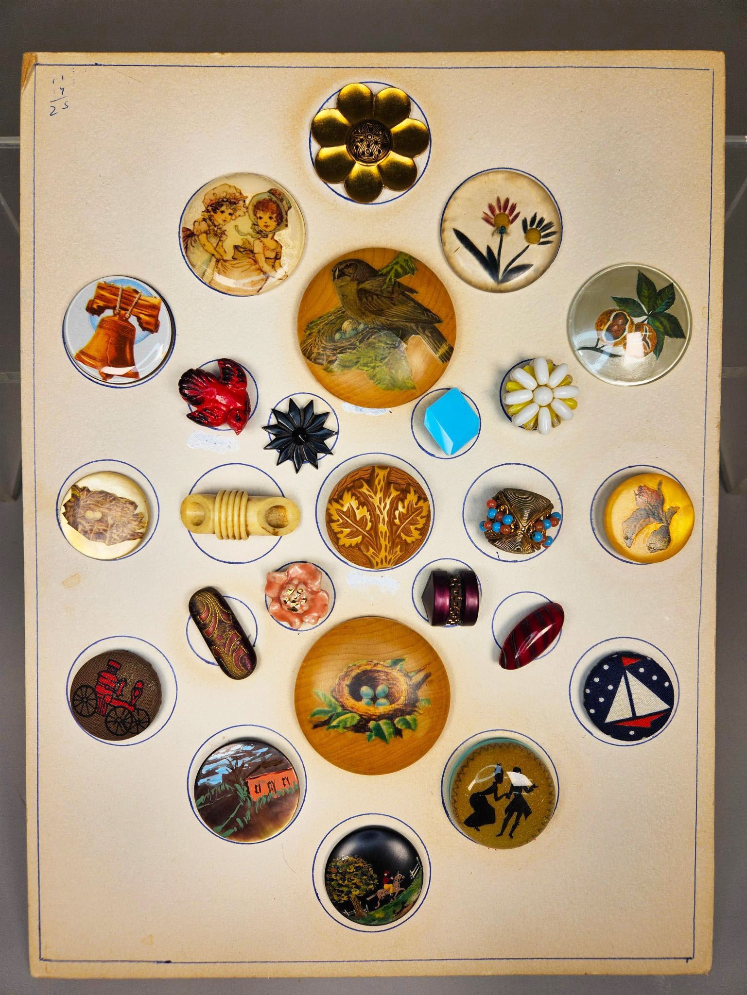 A group of Diverse Antique and Vintage Buttons on Display Card, Late 19th to Mid-20th Century,: This collection comprises group of diverse antique and vintage buttons, dating from the late 19th to mid-20th century, presented on an aged, off-white cardboard display card. The buttons are attached