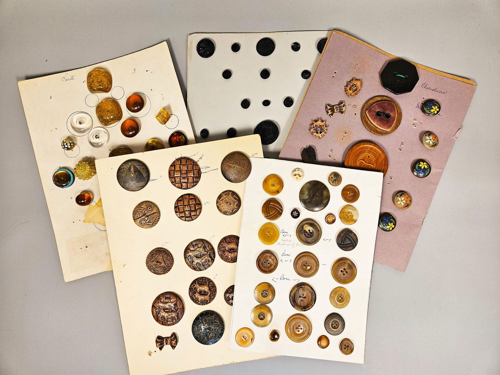 A Collection of Antique and Vintage Buttons, including Division I Black Jet Glass, Lucite, and: A collection of antique and vintage buttons, notably featuring a group of Division I Black Jet Glass buttons. This collection comprises group of mounted sheets displaying a diverse assortment of butto