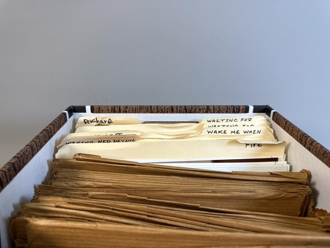 A Collection of Vintage Movie and TV Show Press Kit Photo Stills in a Storage Box: A collection of vintage movie and television show press kit photo stills, housed within a patterned cardboard storage box. The collection comprises numerous black and white photographic movie stills a