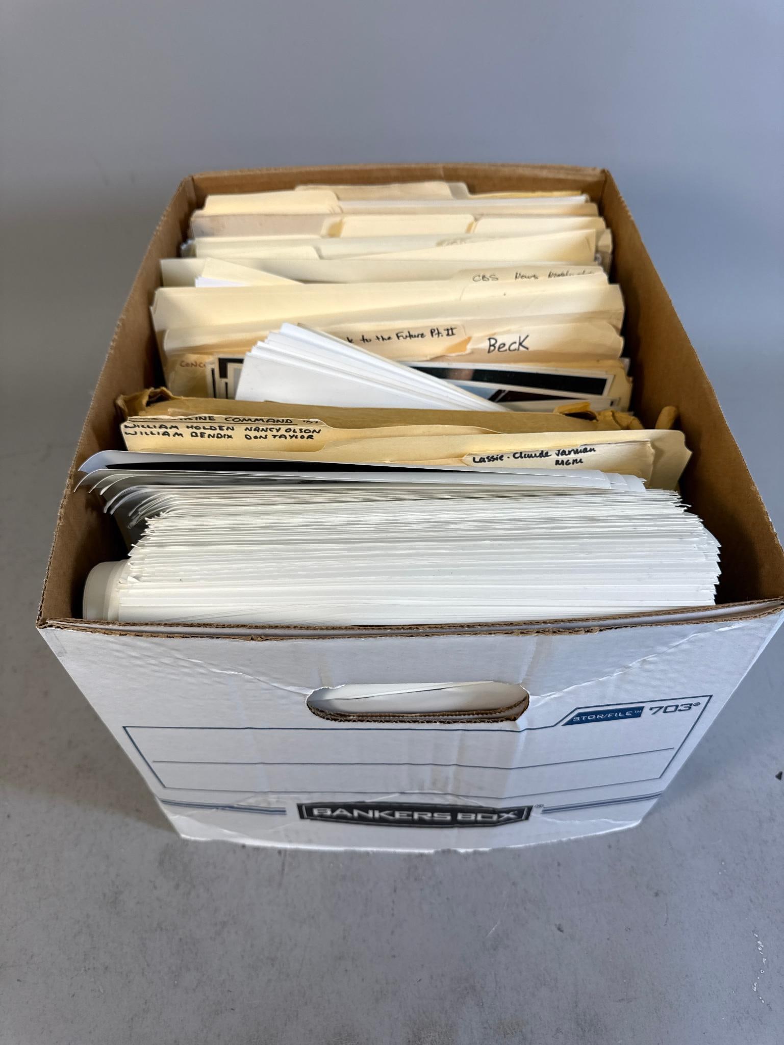 A Collection of Black and White Glossy Promotional Movie and Television Publicity Photos and Press: A collection of black and white glossy promotional movie and television publicity photographs and press materials, housed within a brown cardboard Bankers Box (STOR/FILE 703). The contents include num