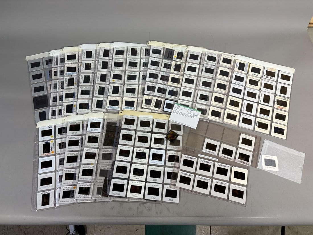 A Collection of German 35mm Film Promotional Slides, 1990s-early 2000s: A collection of numerous 35mm photographic slides, primarily housed within transparent plastic archival sheets and individual cardboard or plastic mounts, with a few loose film strips also present. Th